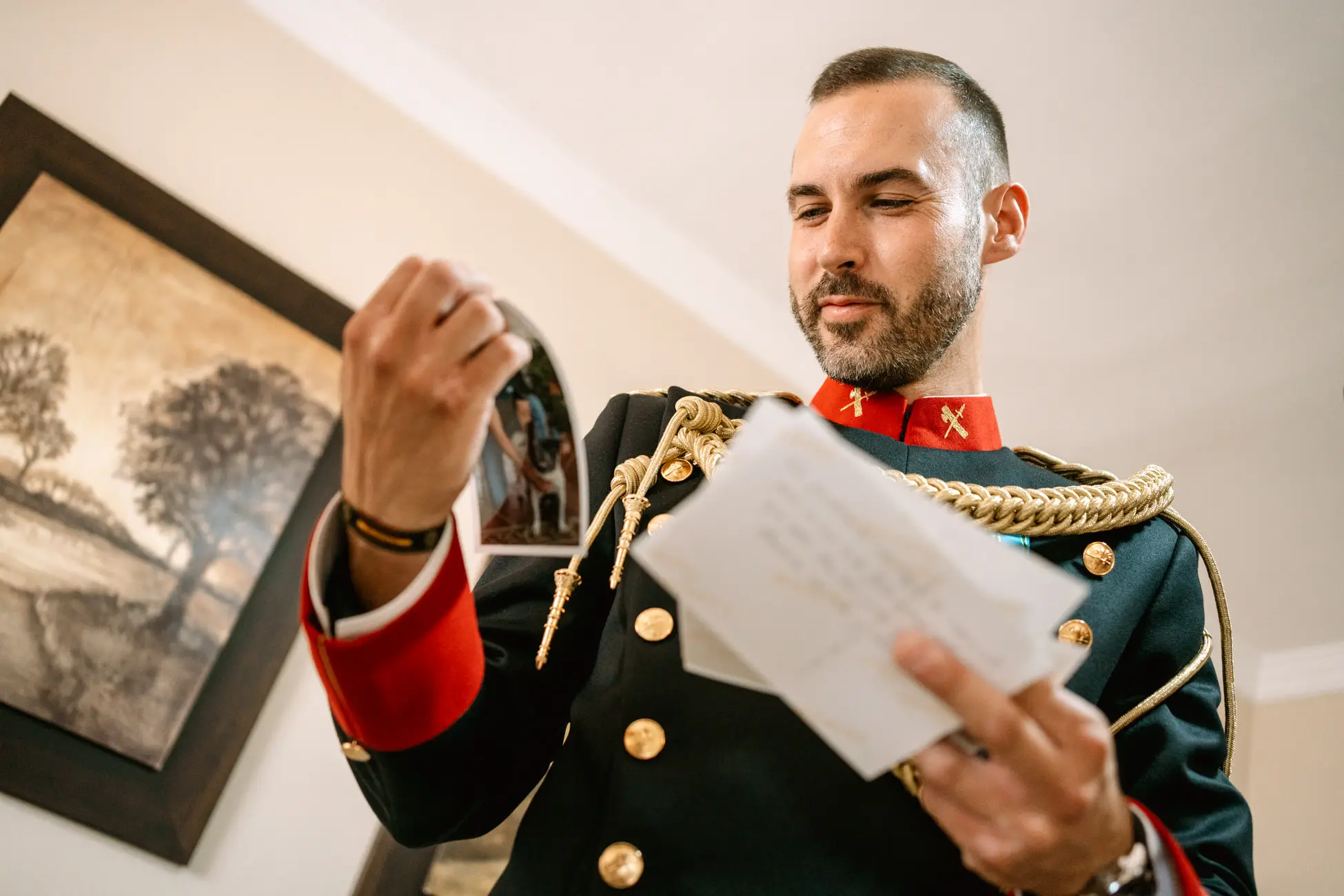 El novio, con uniforme de gala, lee una carta antes de la boda, en Mérida