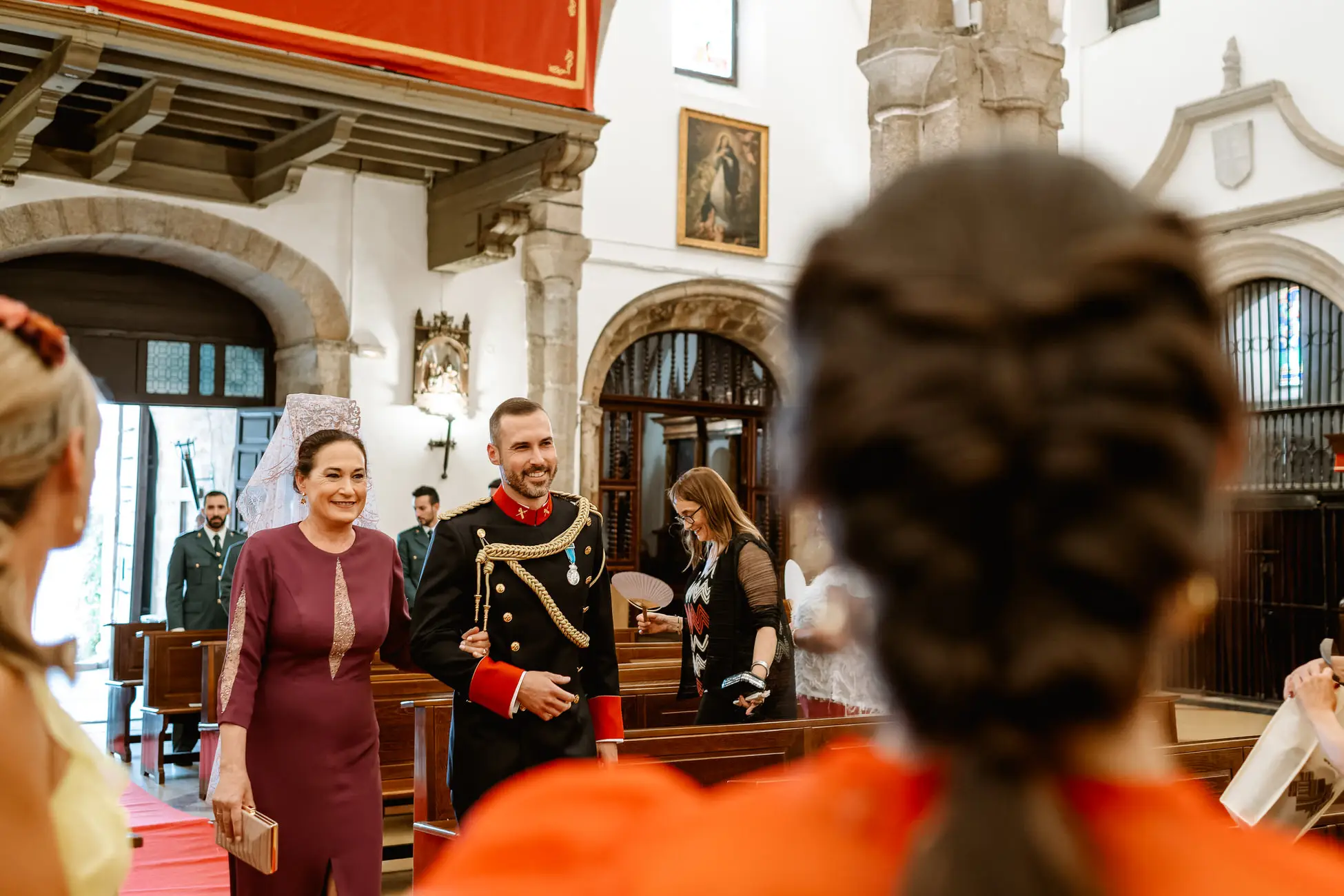 El novio entra en la iglesia con la madrina, que lleva mantilla, en Mérida