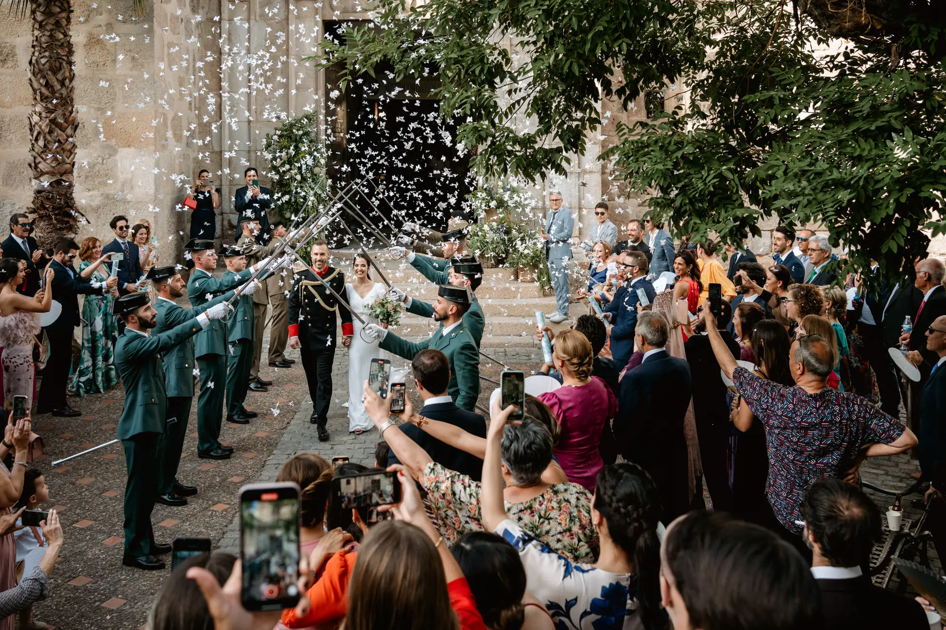 Los invitados graban la salida de los novios bajo los sables, en Mérida