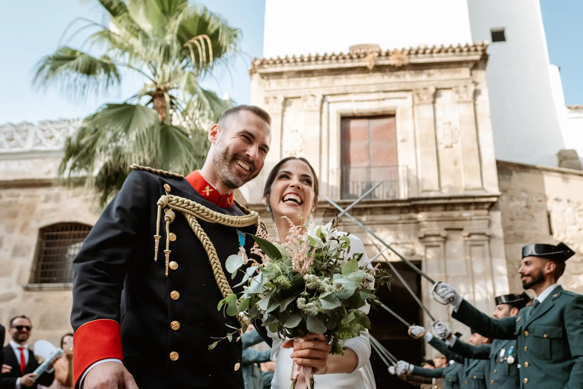 Los novios ríen bajo los sables a la salida de la iglesia, en Mérida