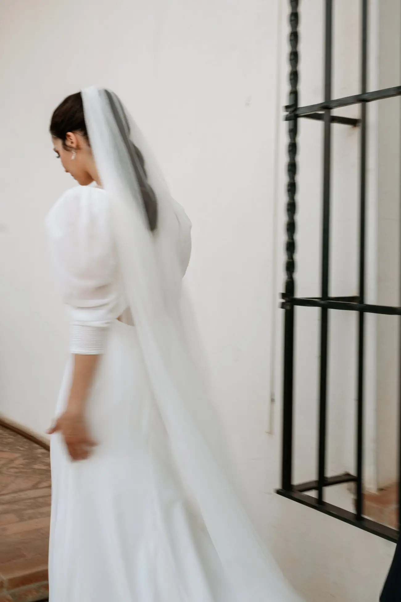 La novia de espaldas con el velo junto a una reja, en Mérida
