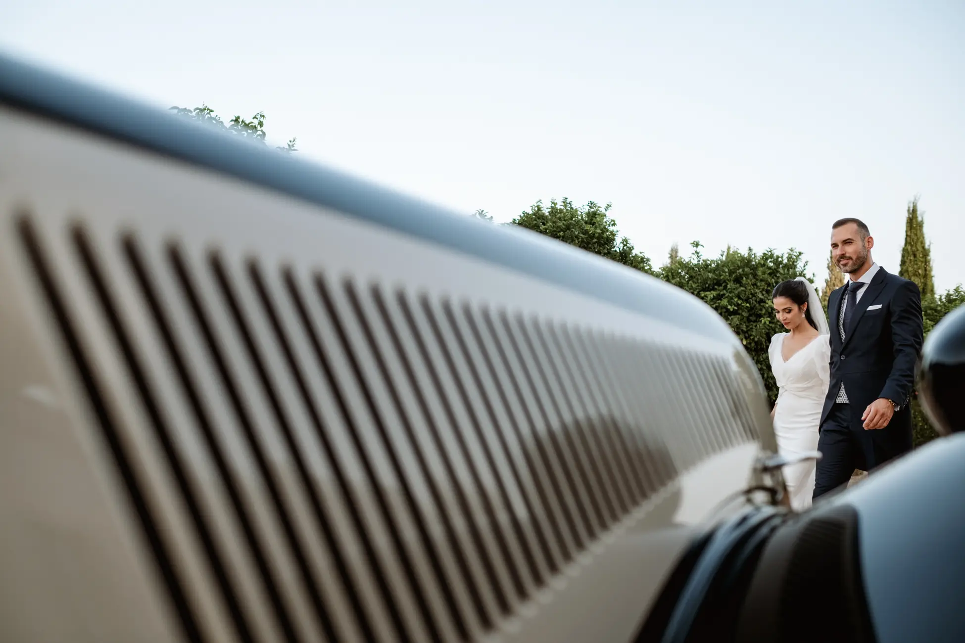 Los novios junto al coche clásico al atardecer, en Mérida