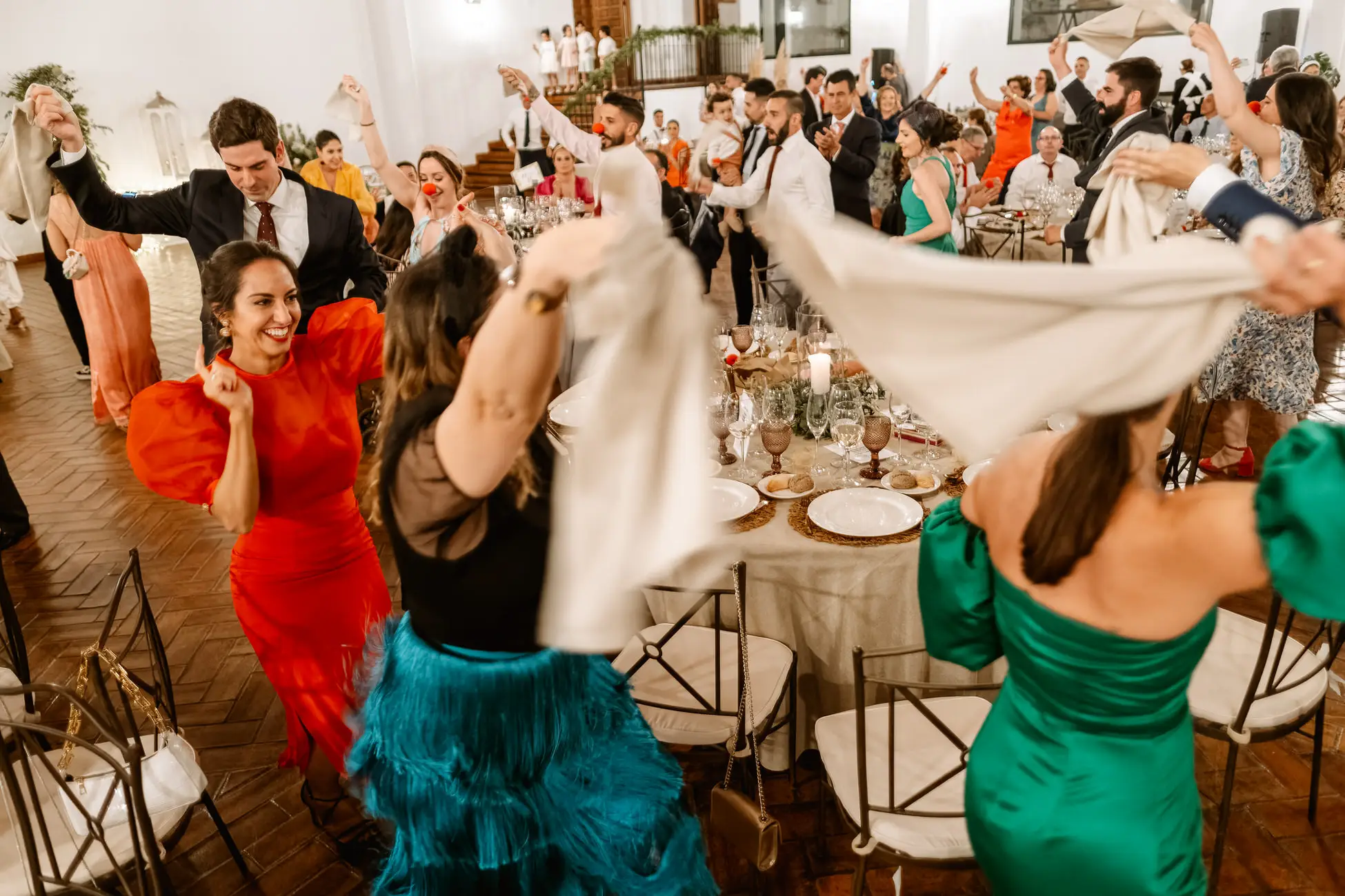 Las invitadas bailan con servilletas entre las mesas, en Mérida