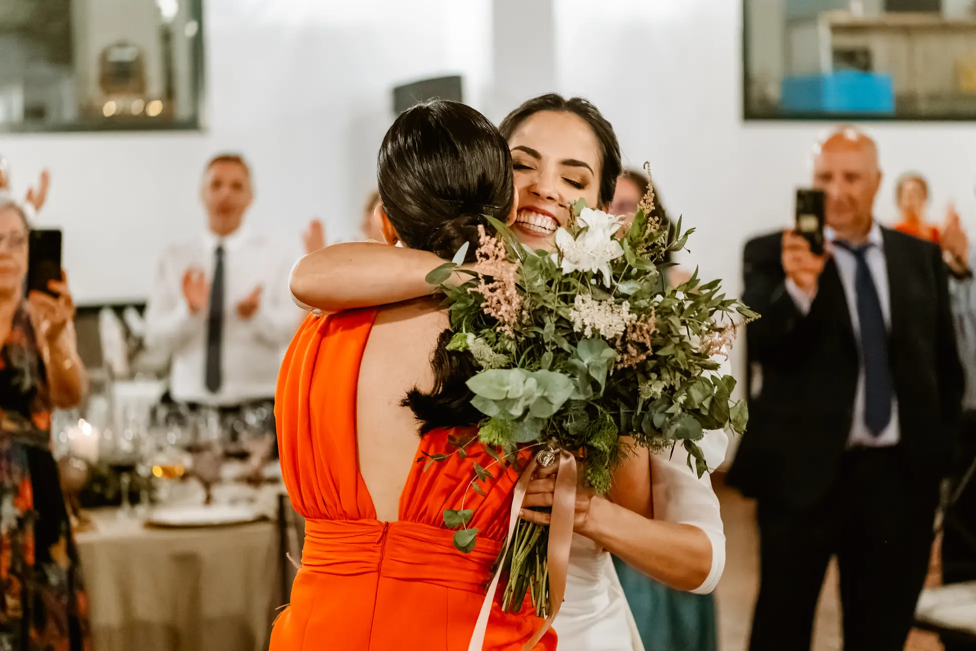 La novia entrega el ramo a una amiga con un abrazo, en Mérida