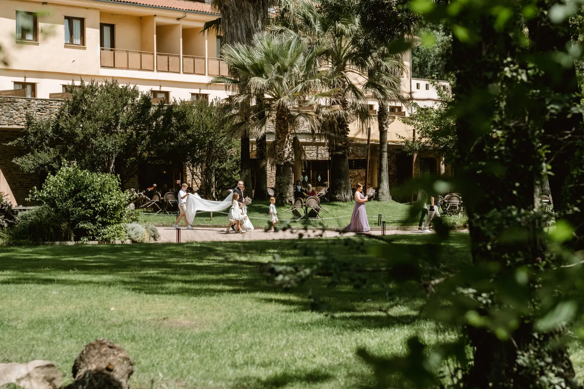 La novia cruza el jardín del balneario hacia la ceremonia