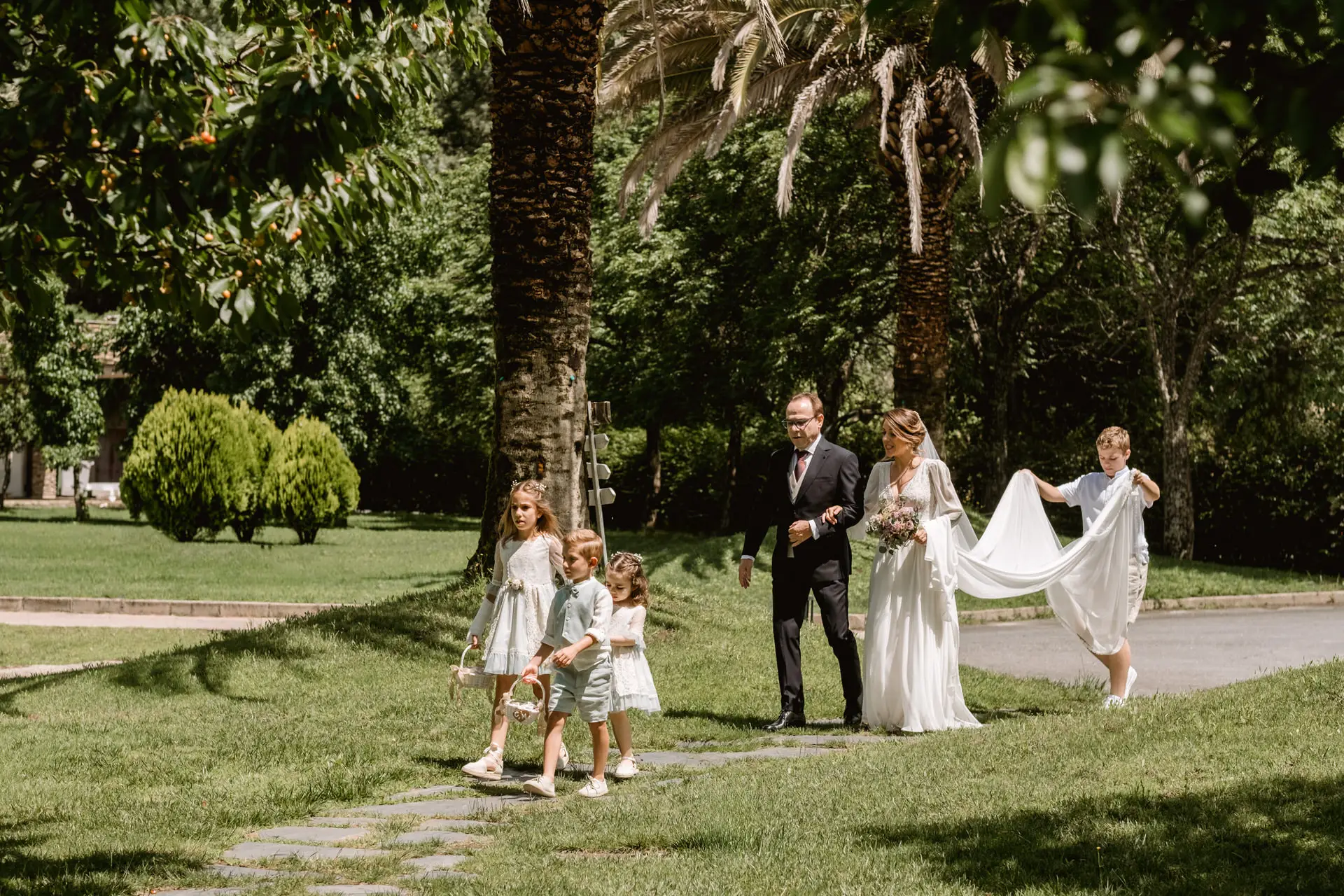 La novia llega con el padrino, detrás de los niños de arras, en el Valle del Jerte (Cáceres)