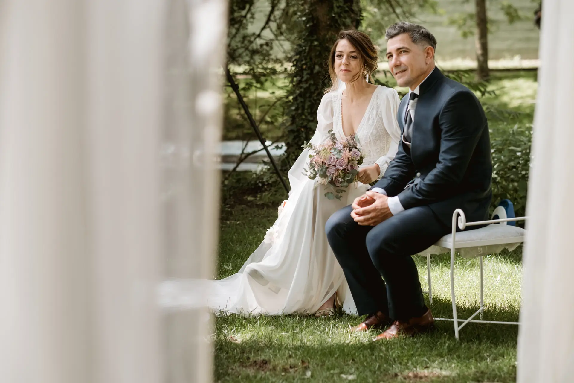 Los novios sentados bajo el arco de telas blancas, en el Valle del Jerte (Cáceres)