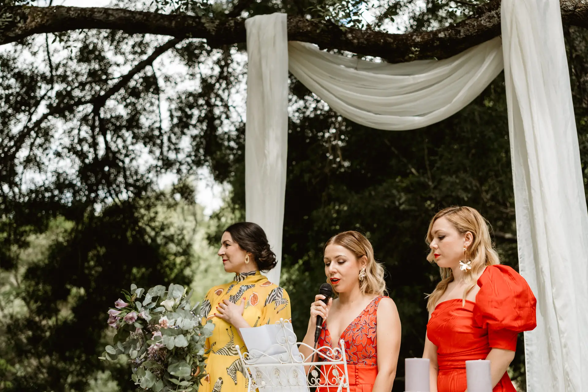 Tres amigas leen junto al arco de telas, en el Valle del Jerte (Cáceres)