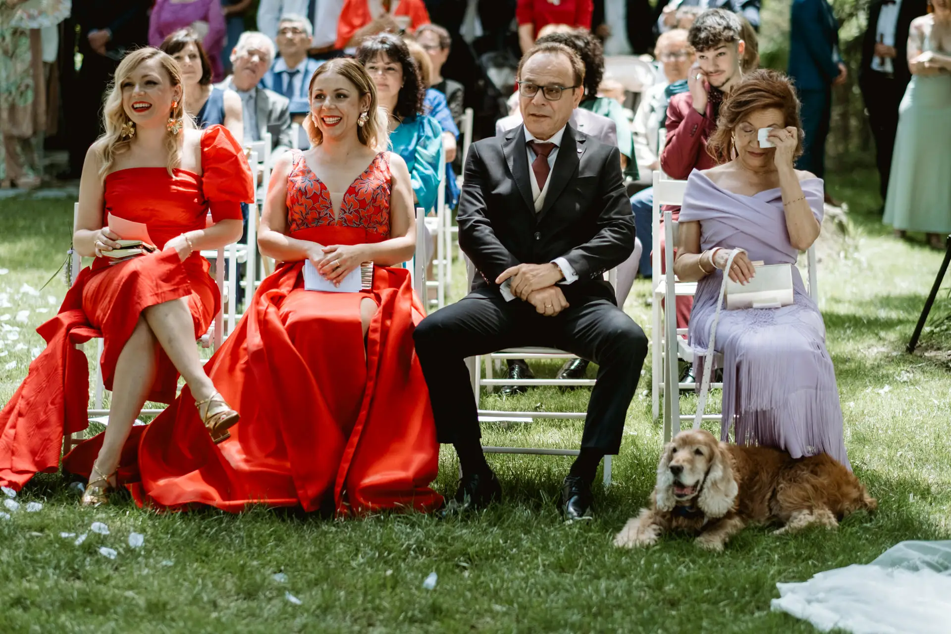 Invitadas emocionadas, con el perro de los novios tumbado en la hierba, en el Valle del Jerte (Cáceres)