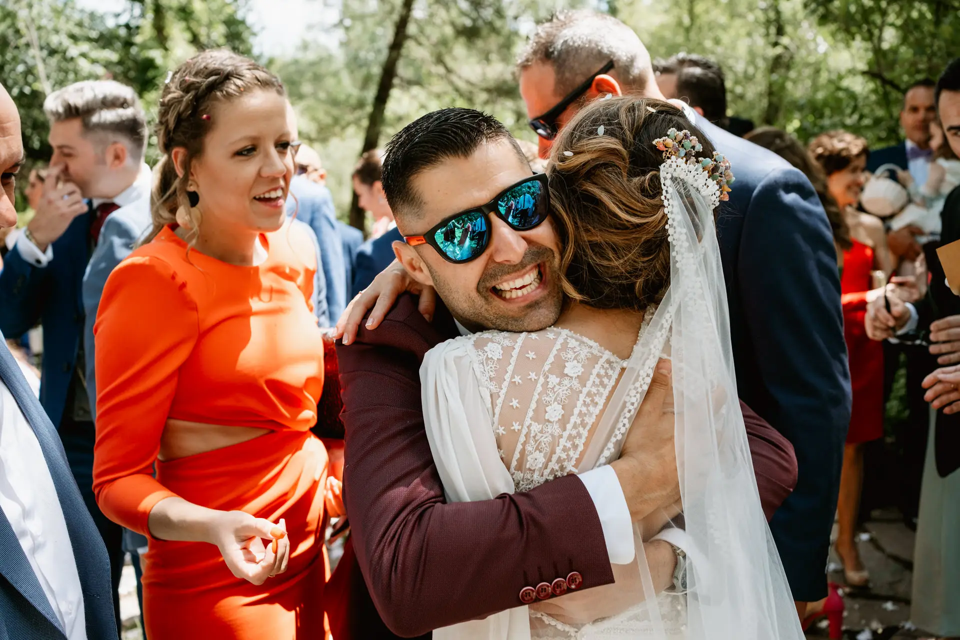 Un amigo con gafas de sol abraza a la novia, en el Valle del Jerte (Cáceres)