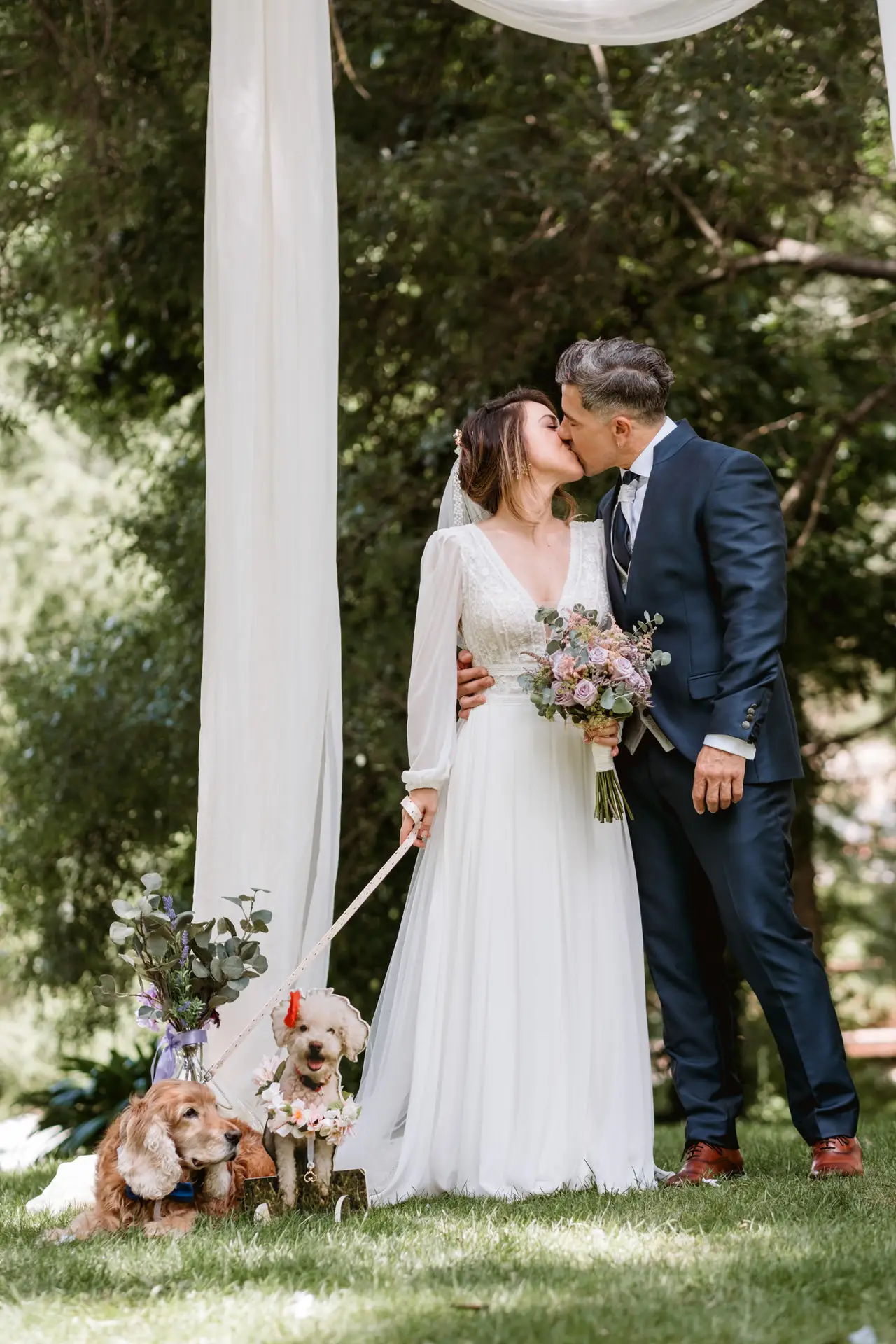 Los novios se besan con su perro bajo el arco de telas, en el Valle del Jerte (Cáceres)