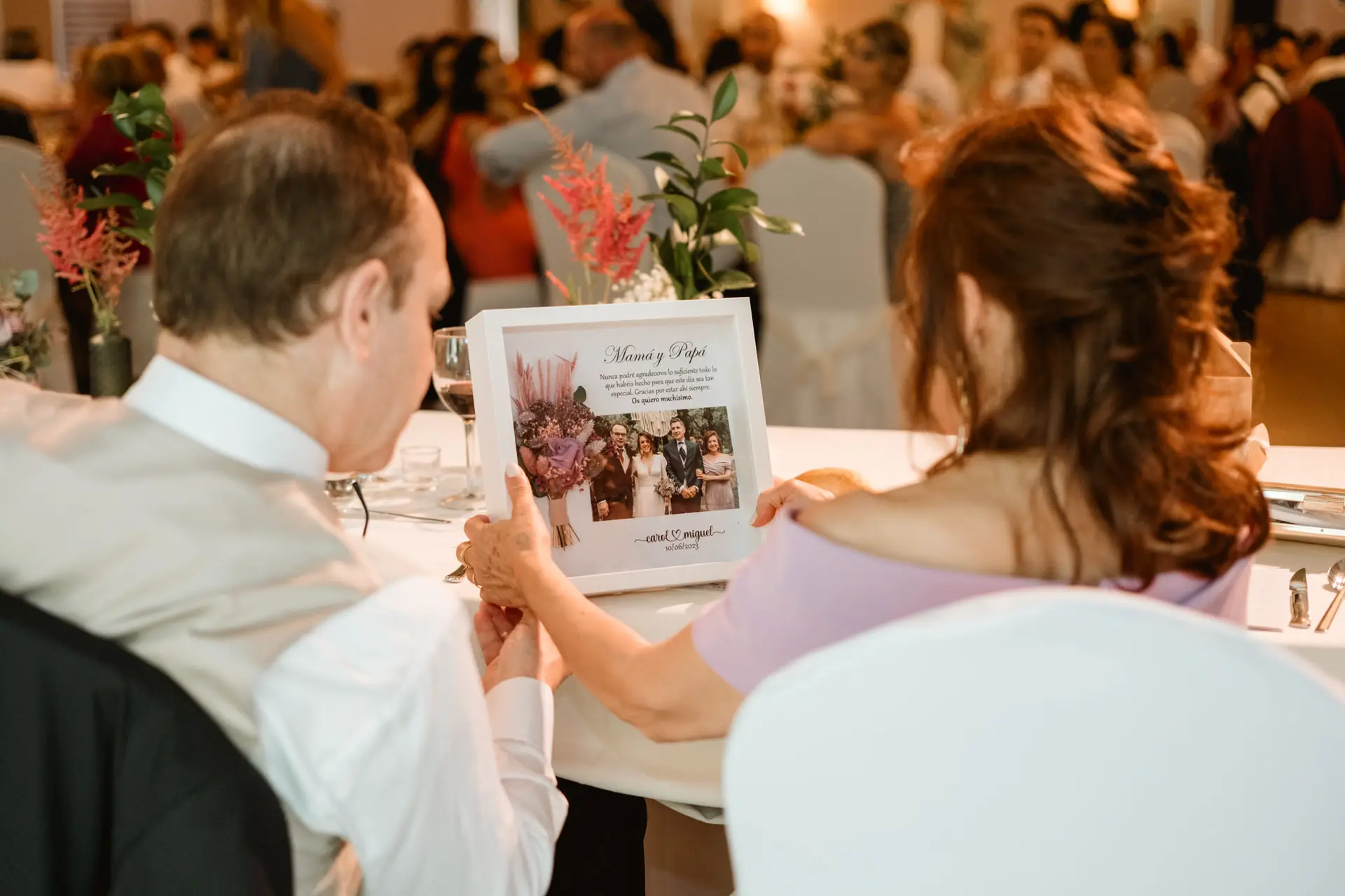 Los invitados miran un regalo con fotos en la mesa, en el Valle del Jerte (Cáceres)