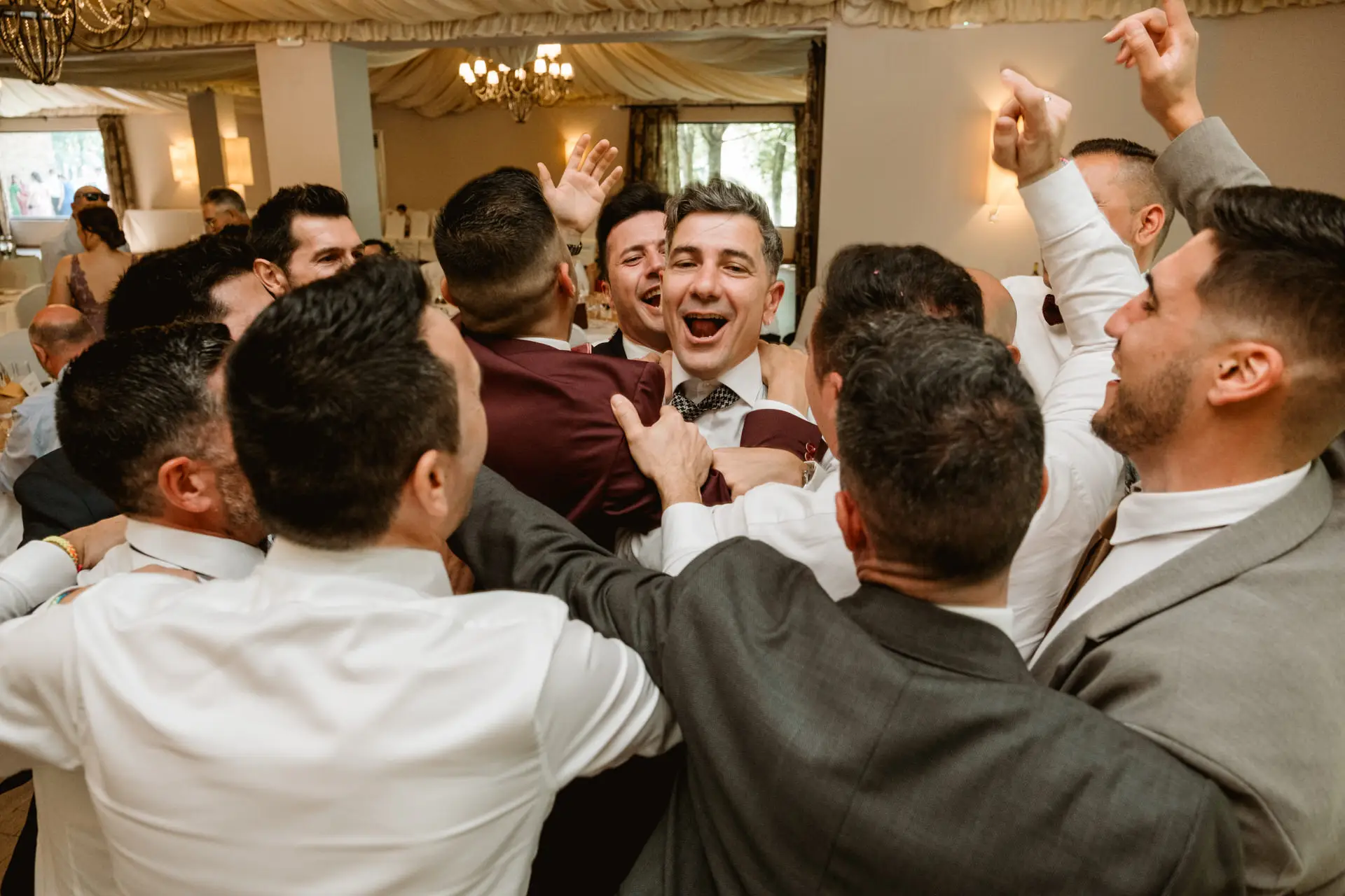 Los amigos rodean al novio en el salón, en el Valle del Jerte (Cáceres)