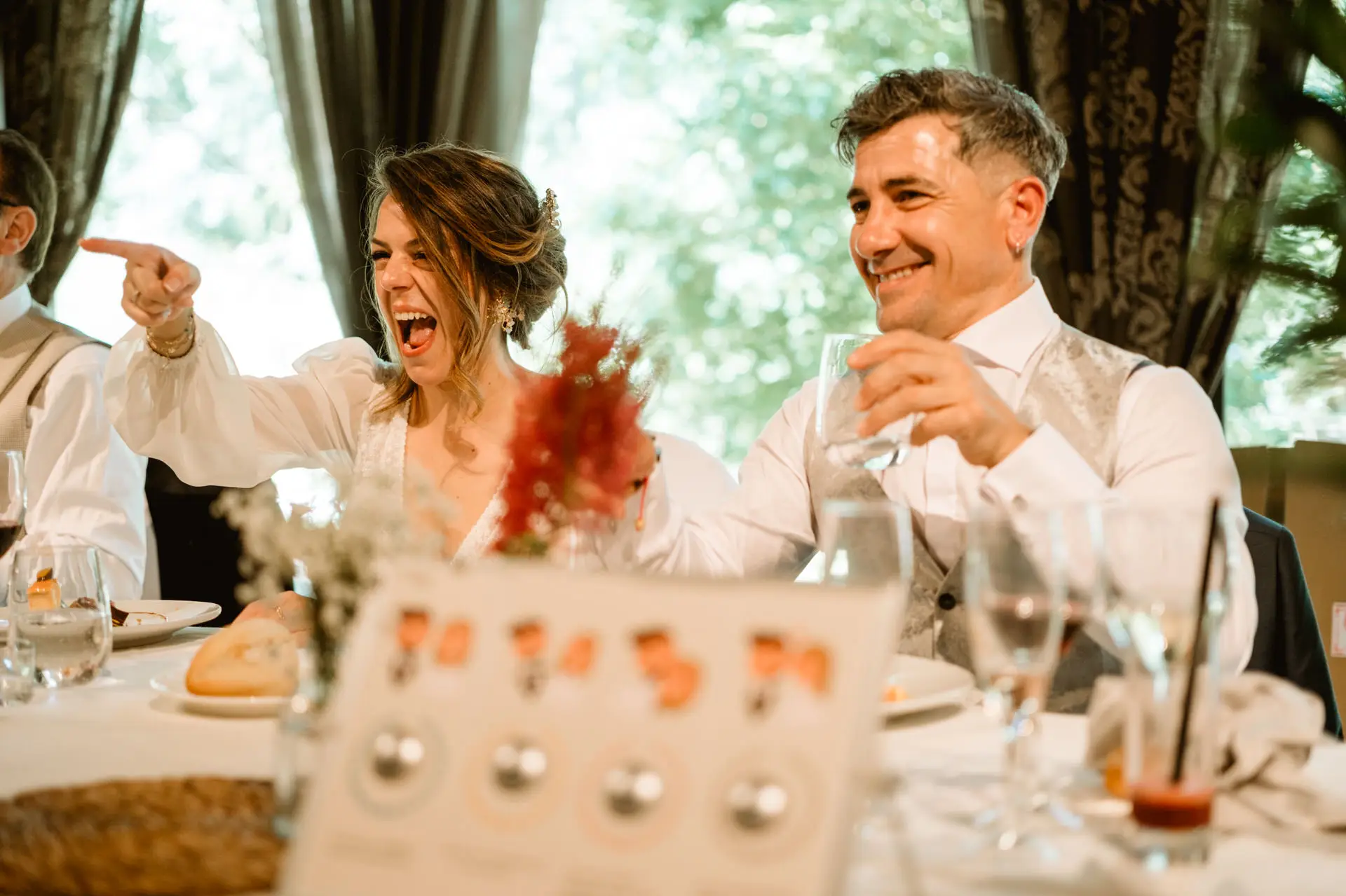 La novia señala riendo en la mesa, en el Valle del Jerte (Cáceres)