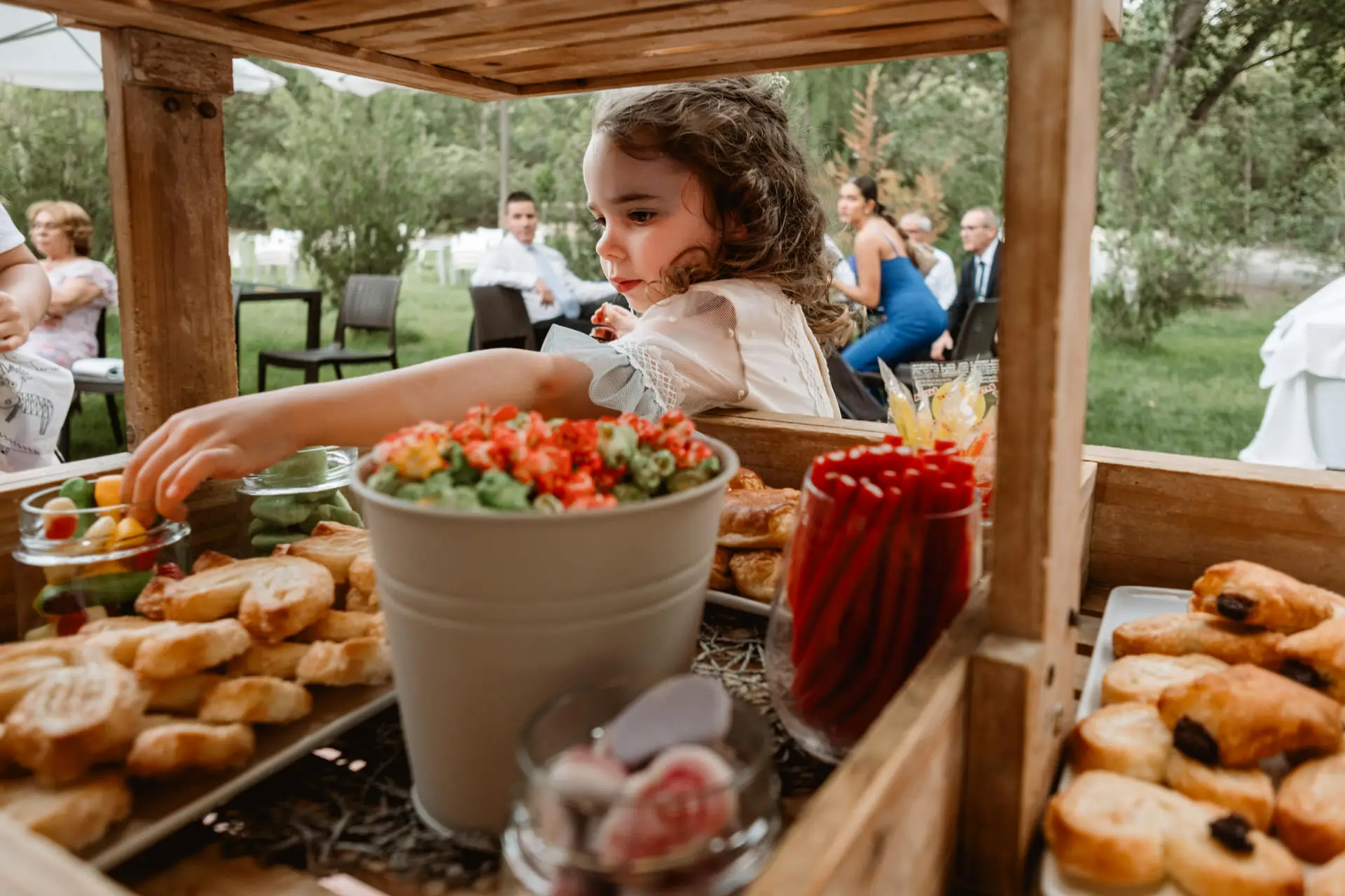 Una niña coge dulces de la mesa de la fiesta, en el Valle del Jerte (Cáceres)