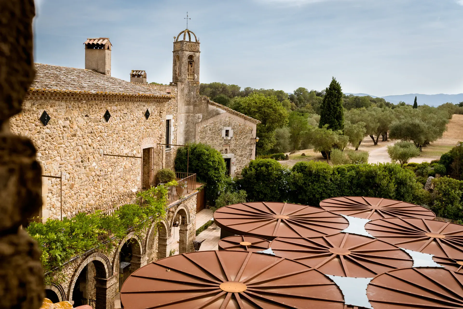 Vista del Hotel Castell d'Empordà y el pueblo entre olivos, Girona