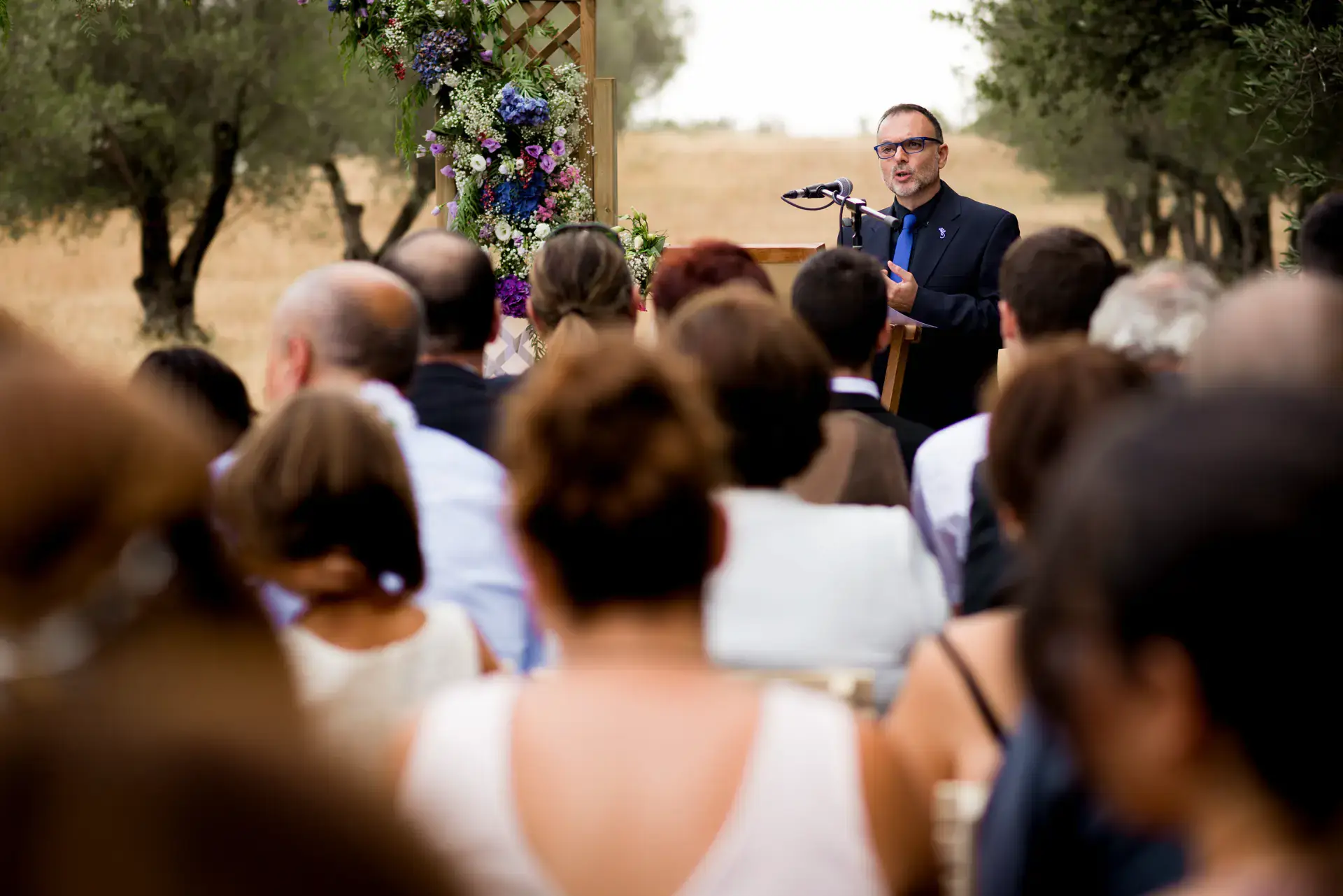 Un invitado lee con micrófono ante los asistentes, en el Castell d'Empordà, Girona