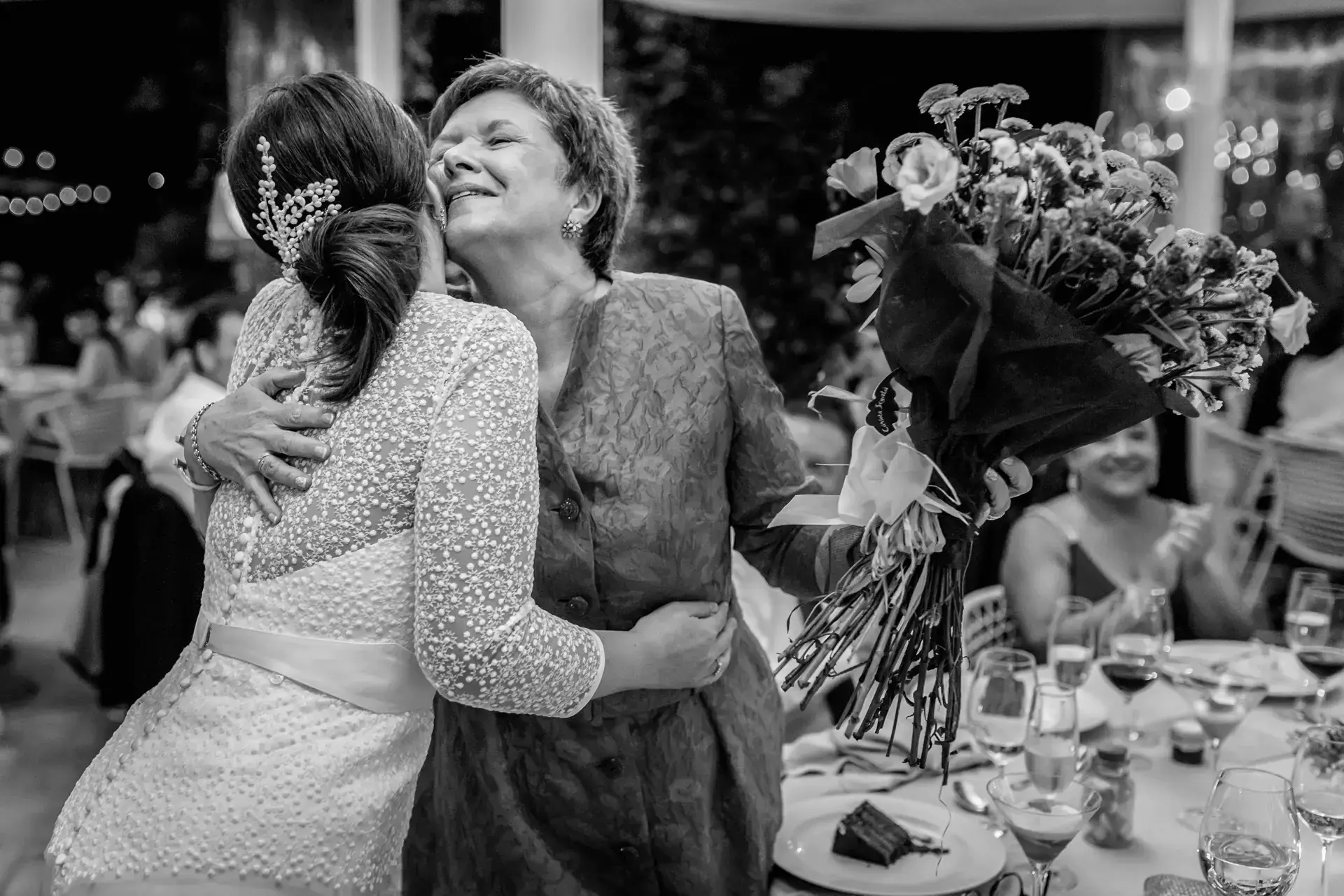 Estefanía abraza a una invitada en el banquete, en blanco y negro, en el Castell d'Empordà, Girona
