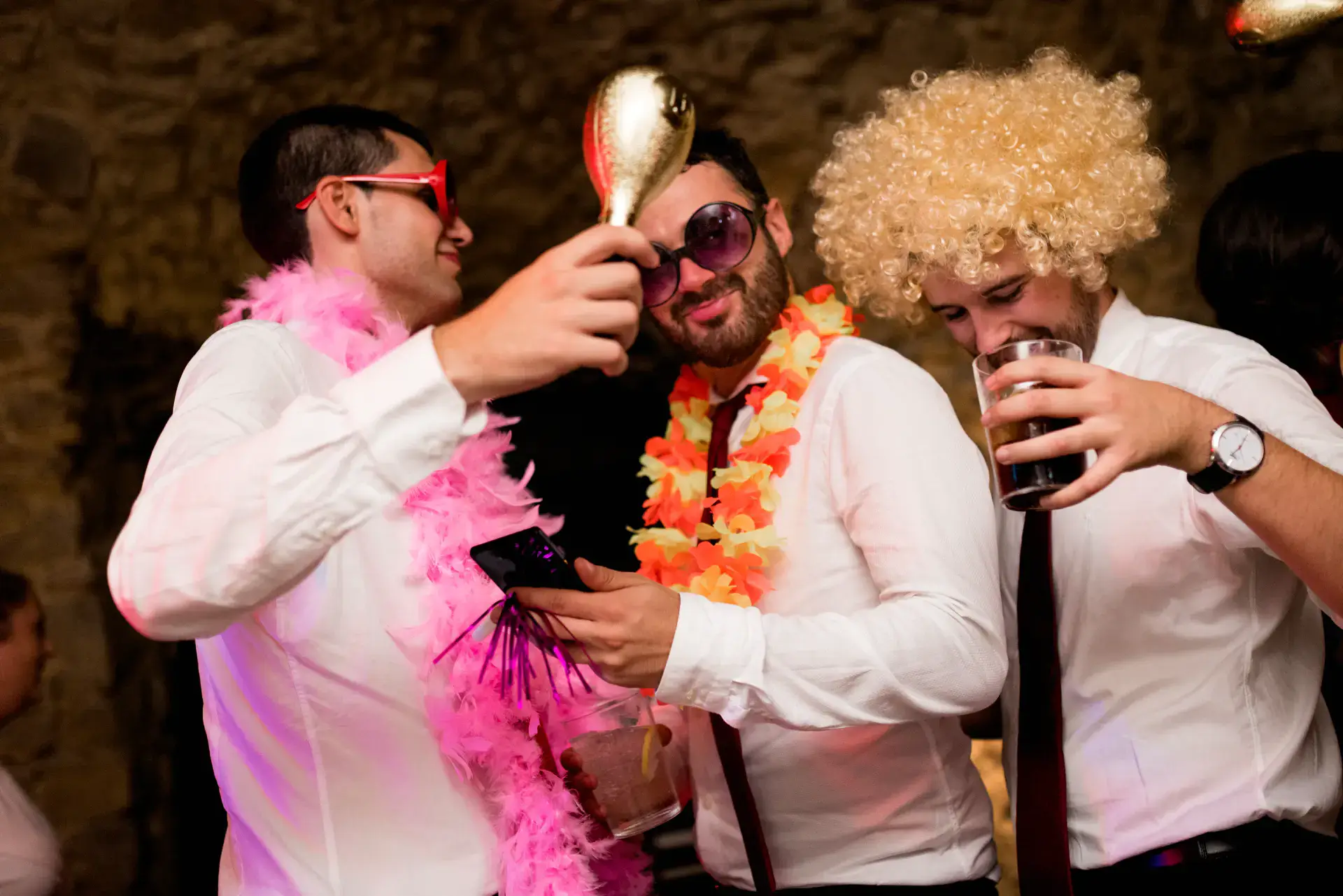 Invitados con pelucas y boas de plumas en la fiesta, en el Castell d'Empordà, Girona