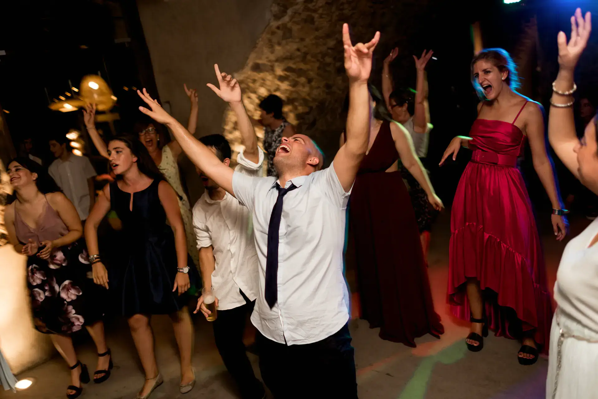 Invitados bailan con los brazos en alto en la pista, en el Castell d'Empordà, Girona