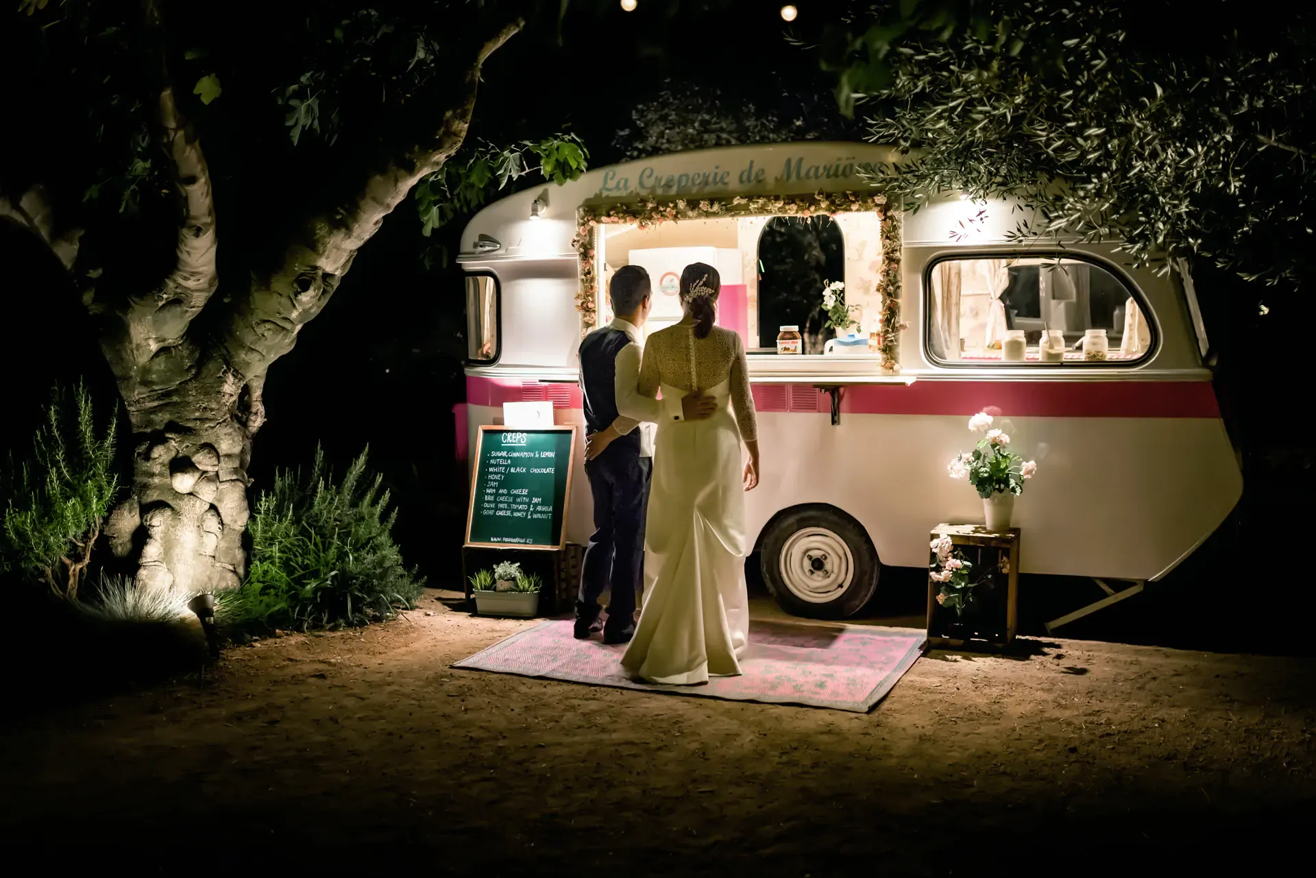Albert y Estefanía junto a una caravana fotomatón de noche en el Hotel Castell d'Empordà (Girona)
