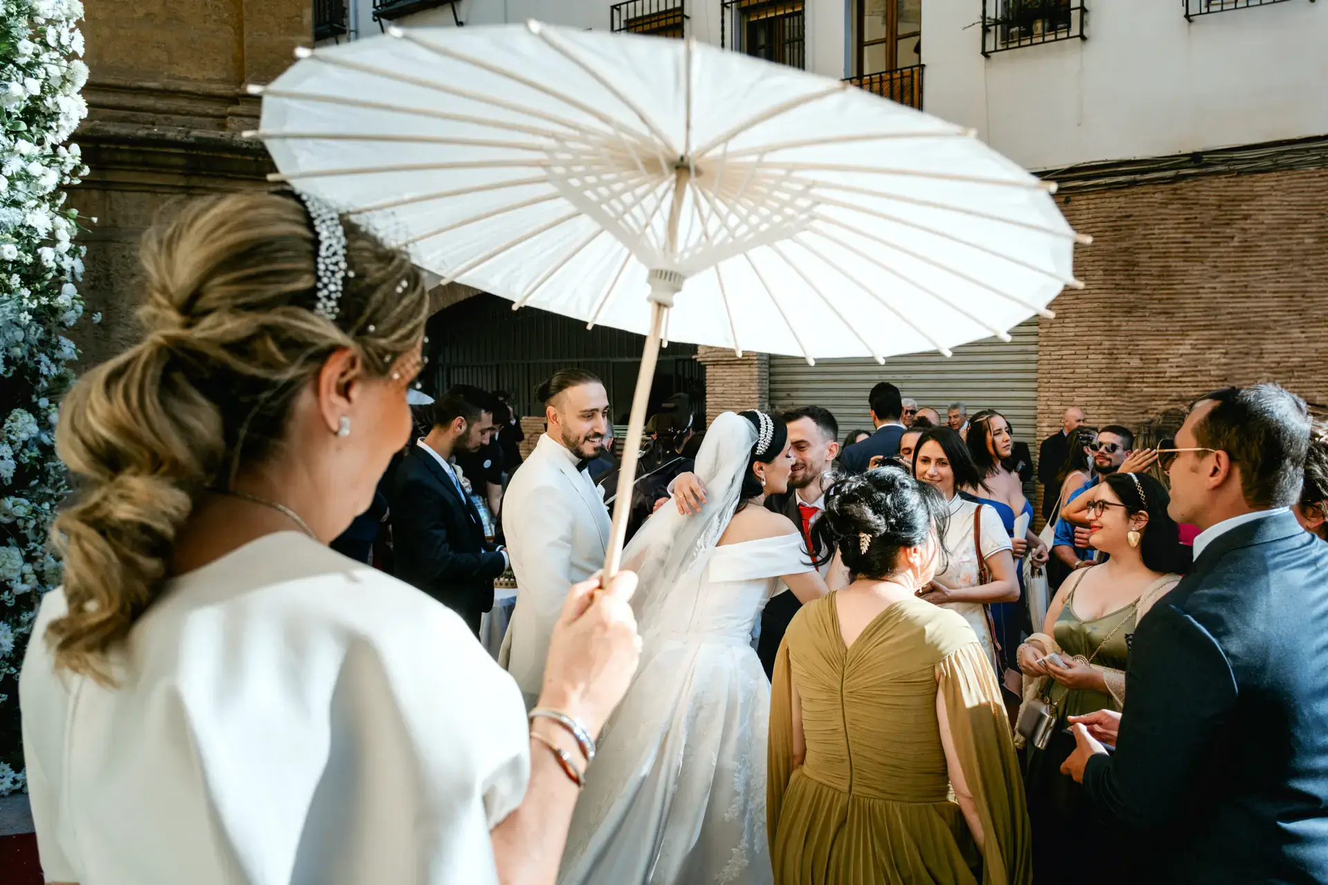 Una invitada con sombrilla blanca a la salida de la iglesia, en Córdoba