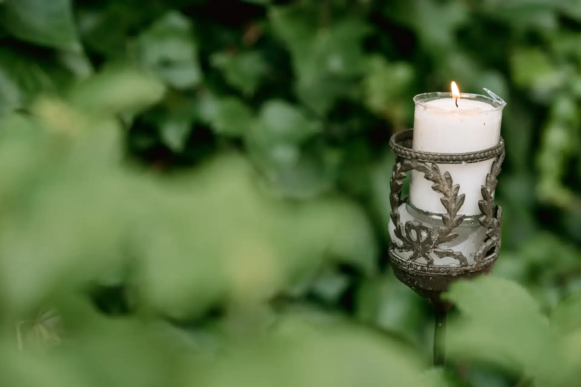 Vela en un farol entre la vegetación, en Córdoba
