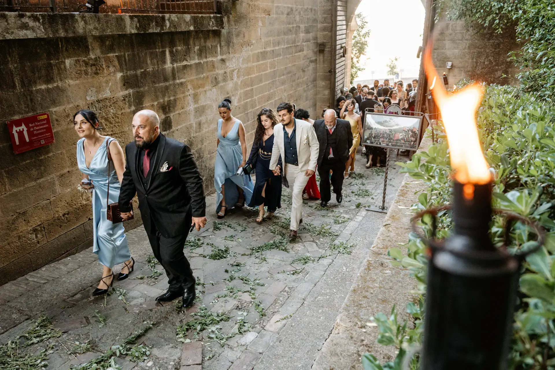 Invitados suben al castillo junto a una antorcha