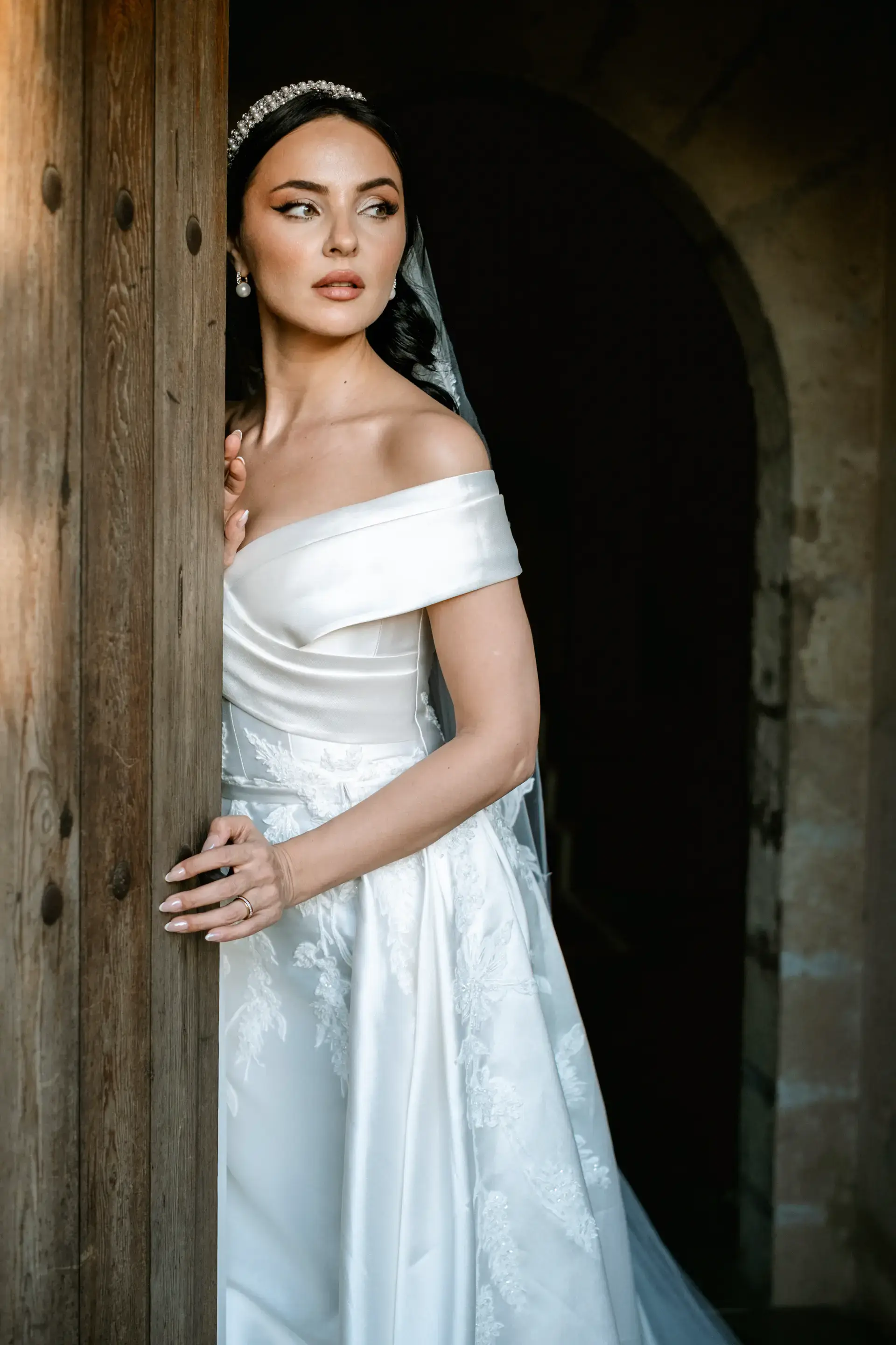 Nicole apoyada en una puerta de madera del castillo