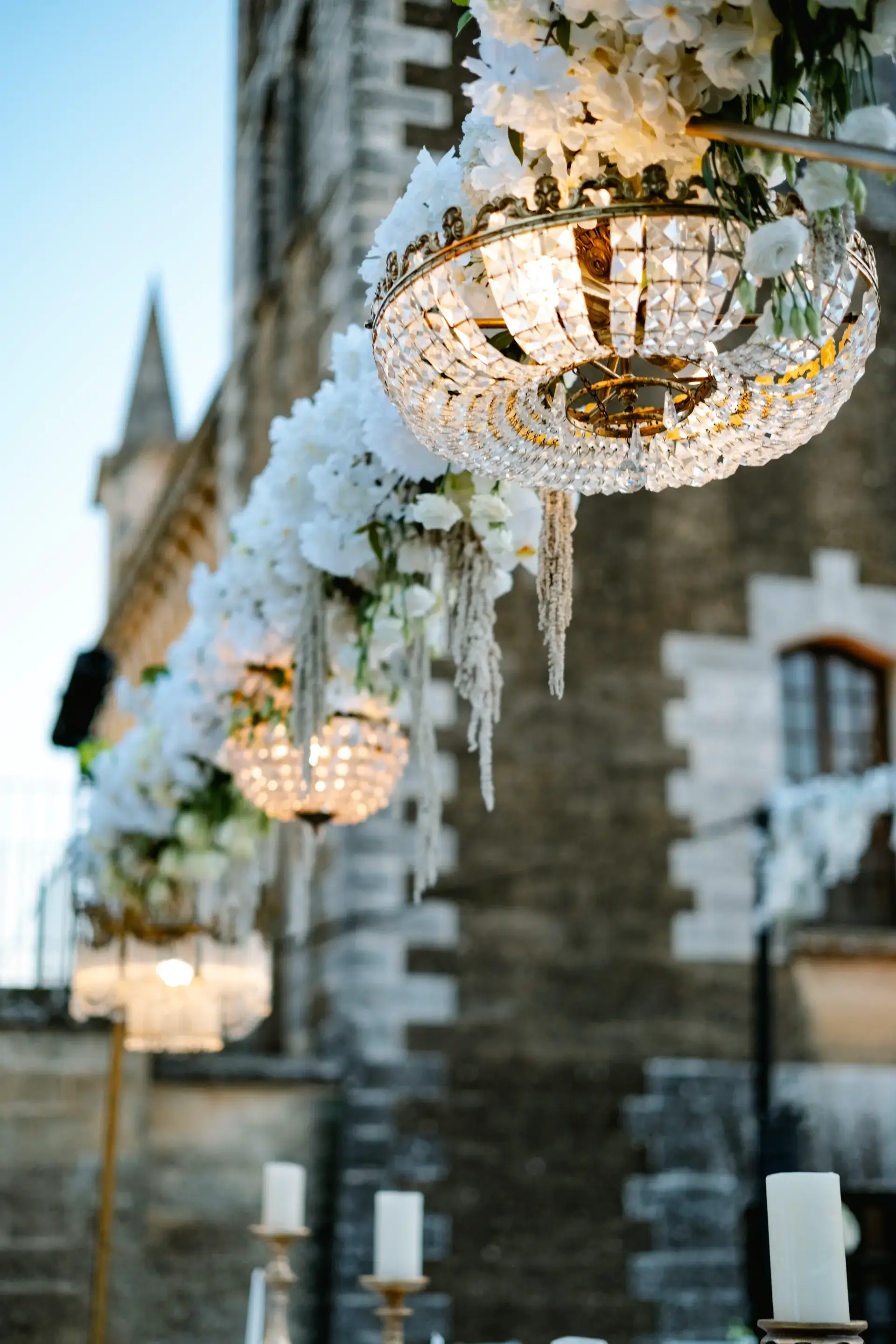 Lámparas de cristal y flores colgando junto a la torre del castillo