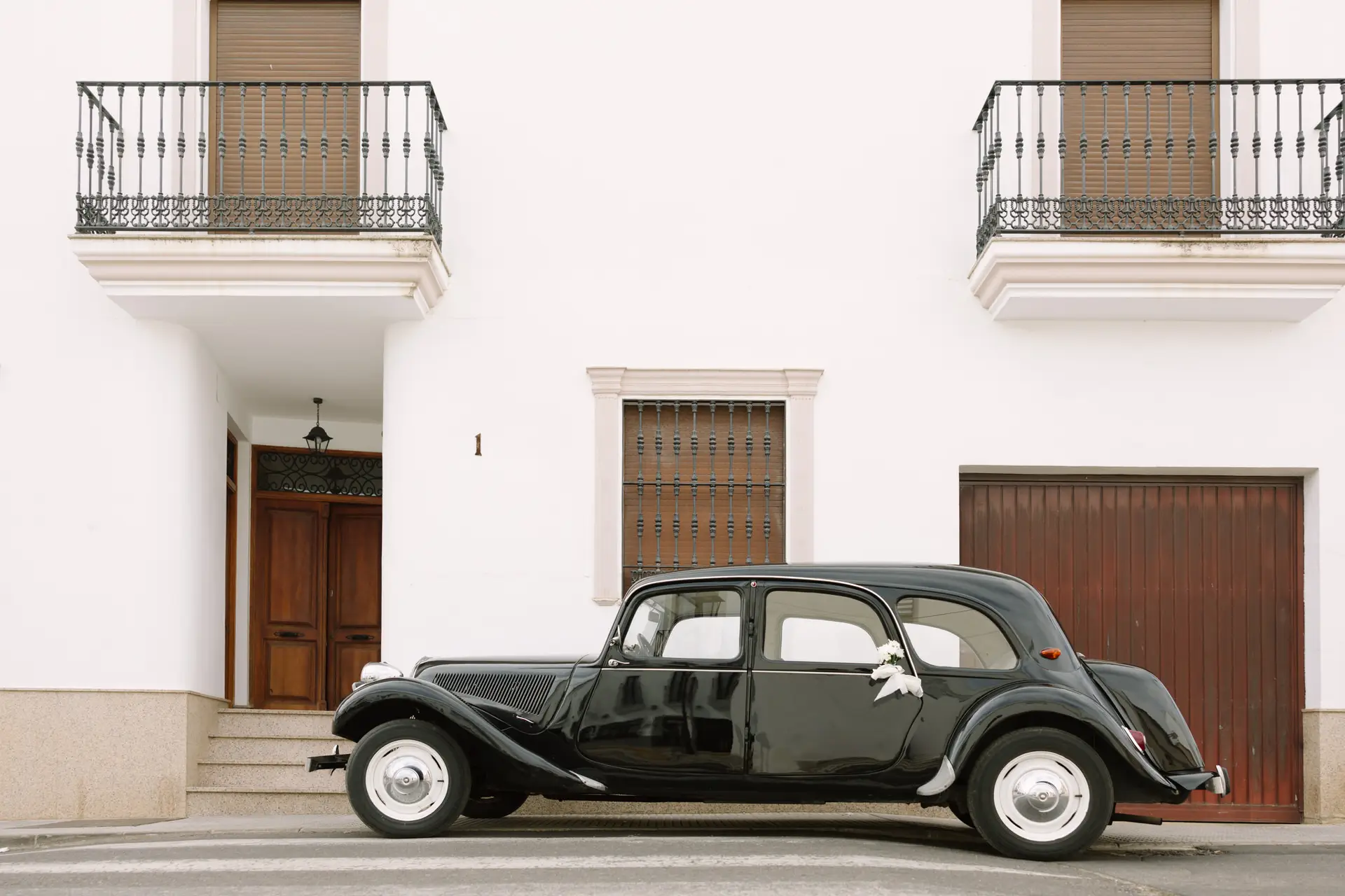 Coche clásico negro aparcado ante una casa blanca de Jerez de los Caballeros