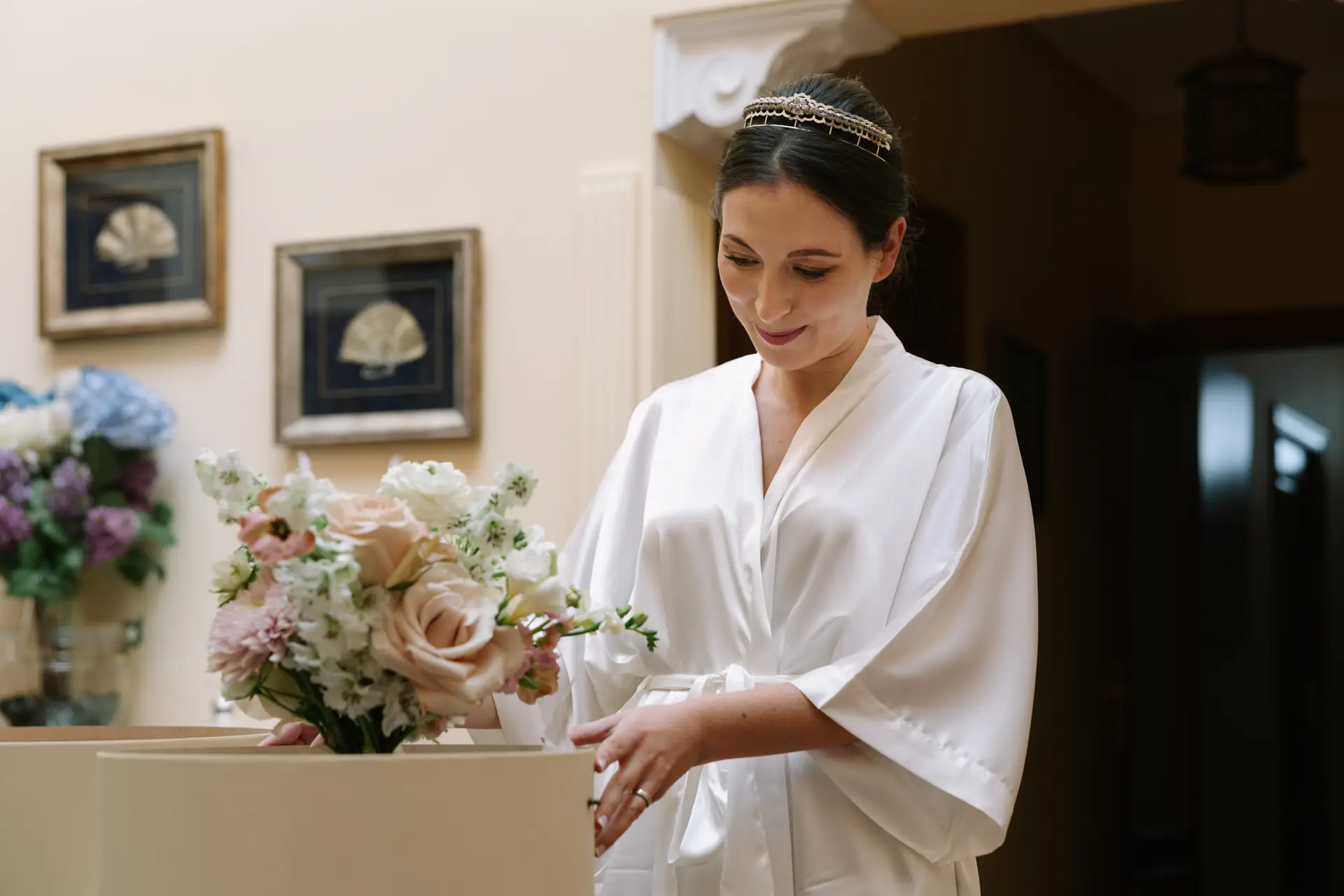 Laura, en bata, mira su ramo de flores, en Jerez de los Caballeros
