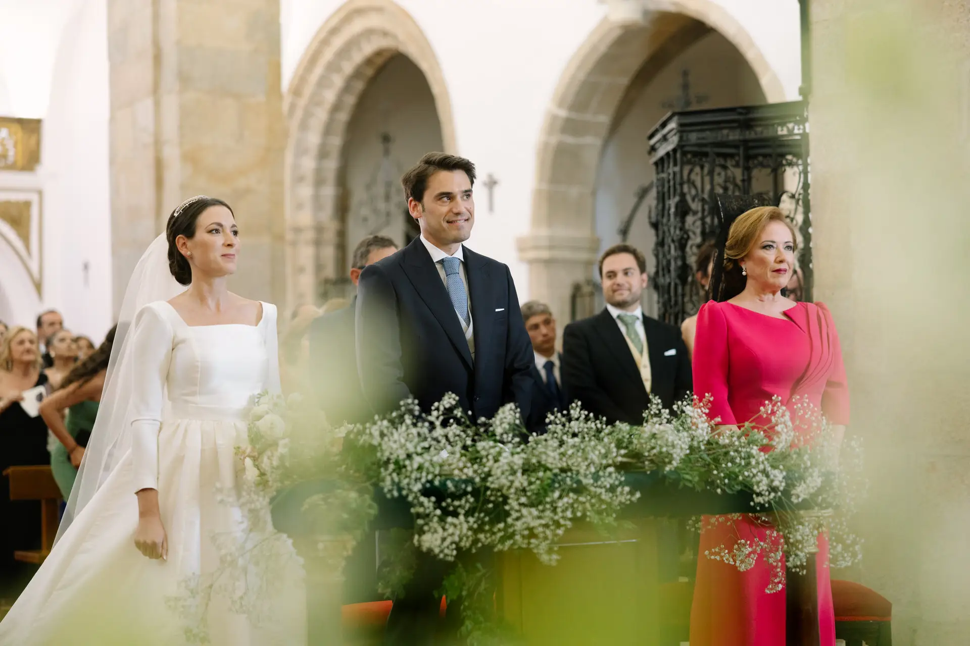 Laura y José Carlos en el altar entre flores de paniculata, en Jerez de los Caballeros
