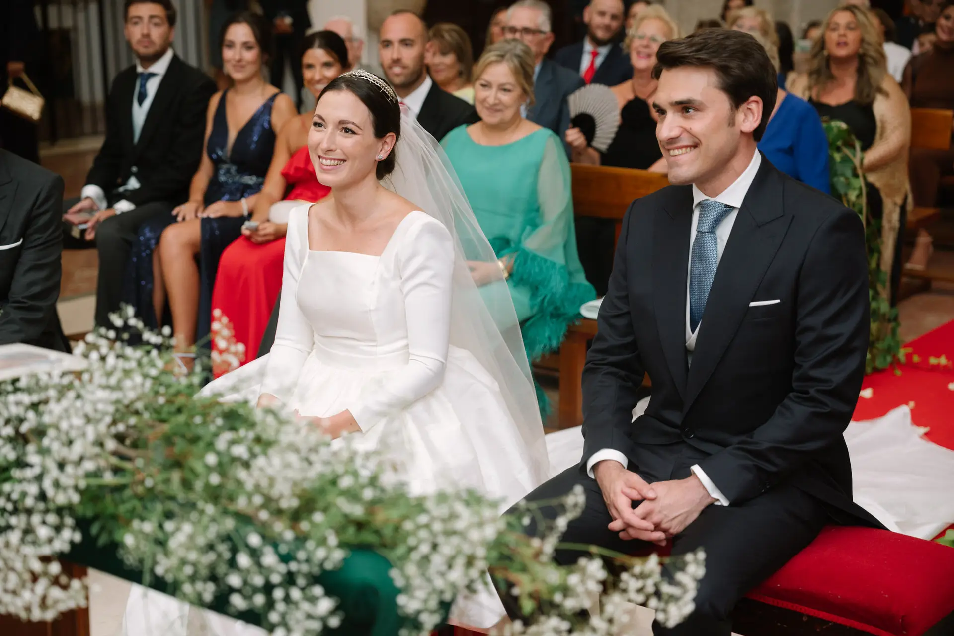 Laura y José Carlos sonríen sentados en el altar, en Jerez de los Caballeros
