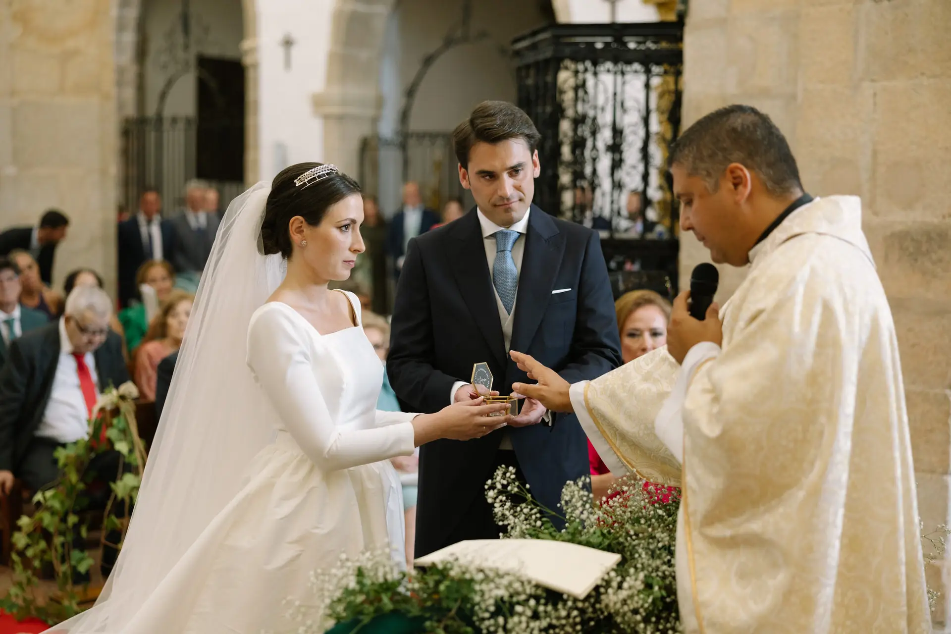 Laura y José Carlos con el sacerdote durante las arras, en Jerez de los Caballeros