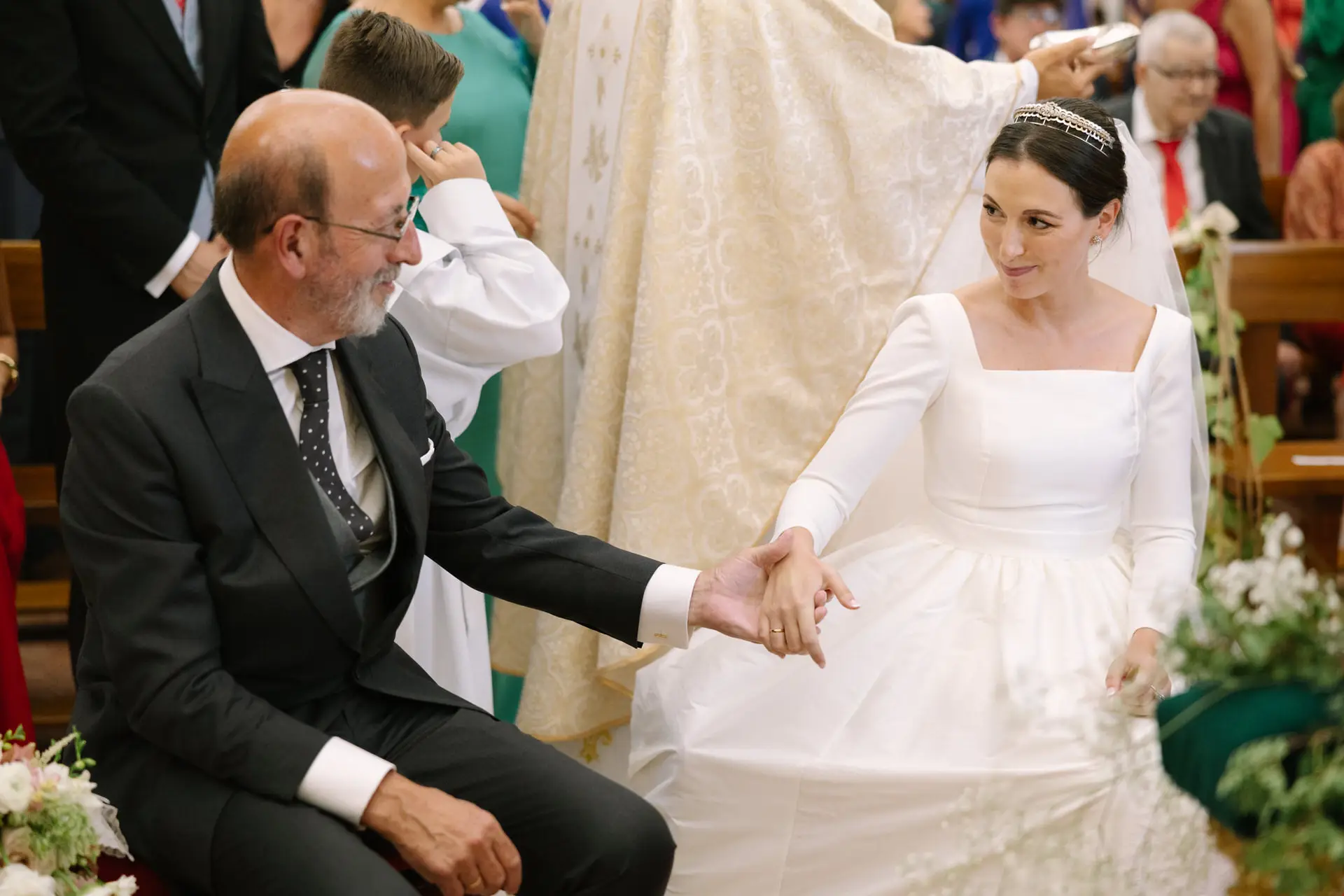 Laura da la mano a un familiar en el altar, en Jerez de los Caballeros