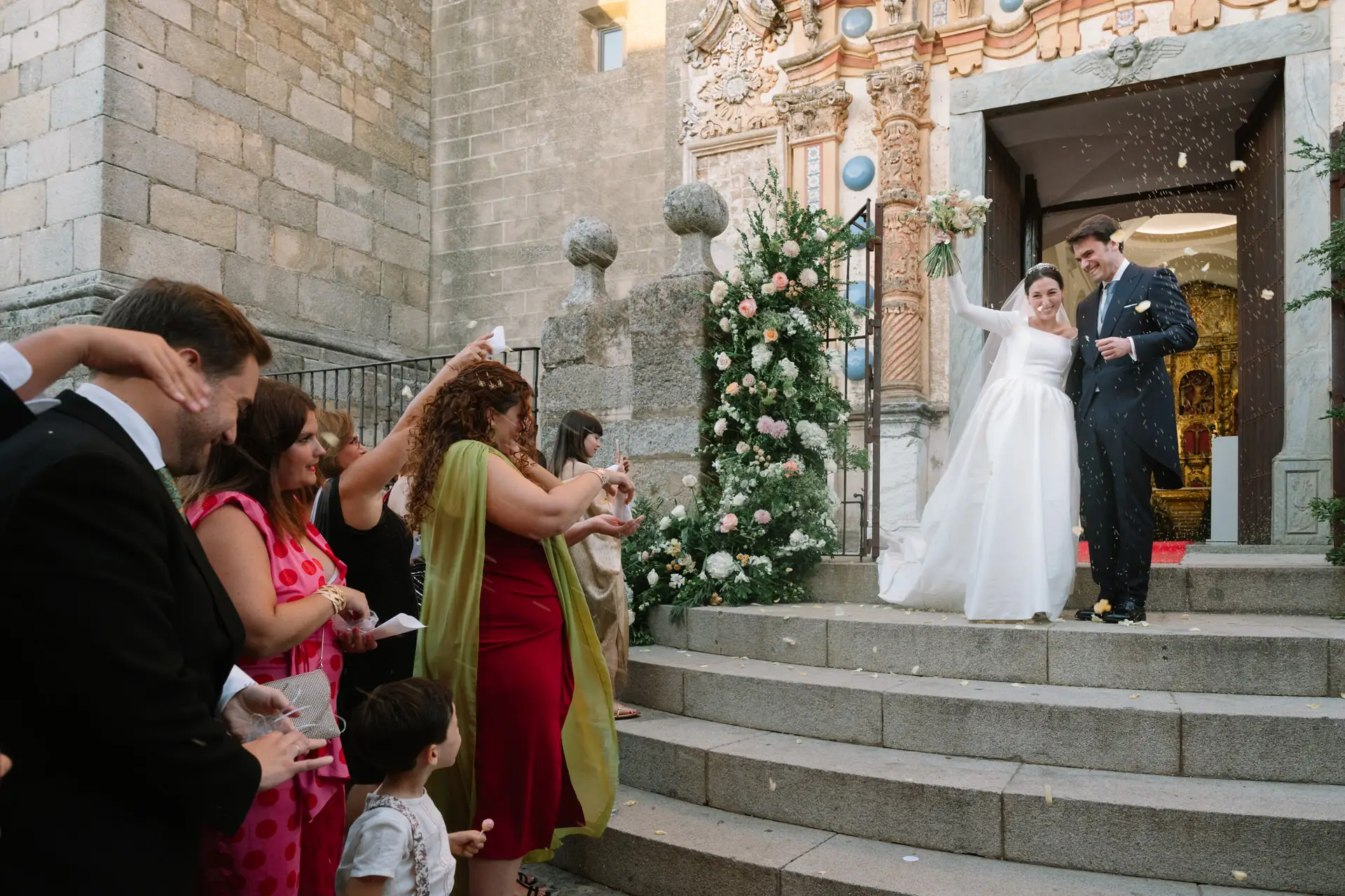 Los novios salen de la iglesia mientras los invitados lanzan arroz, en Jerez de los Caballeros