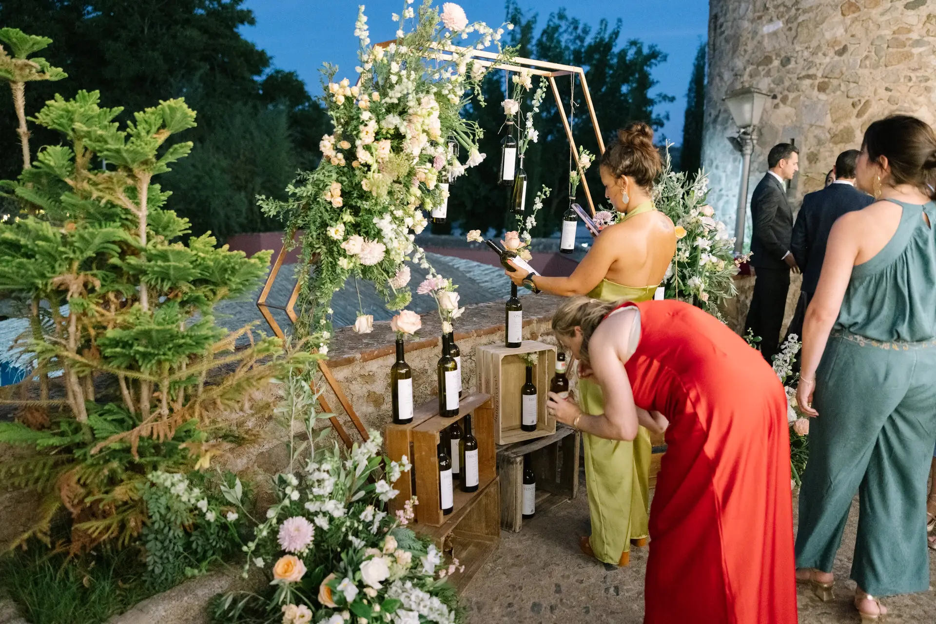 Invitadas junto a un rincón de flores y vinos en el Castillo de Toriñuelo