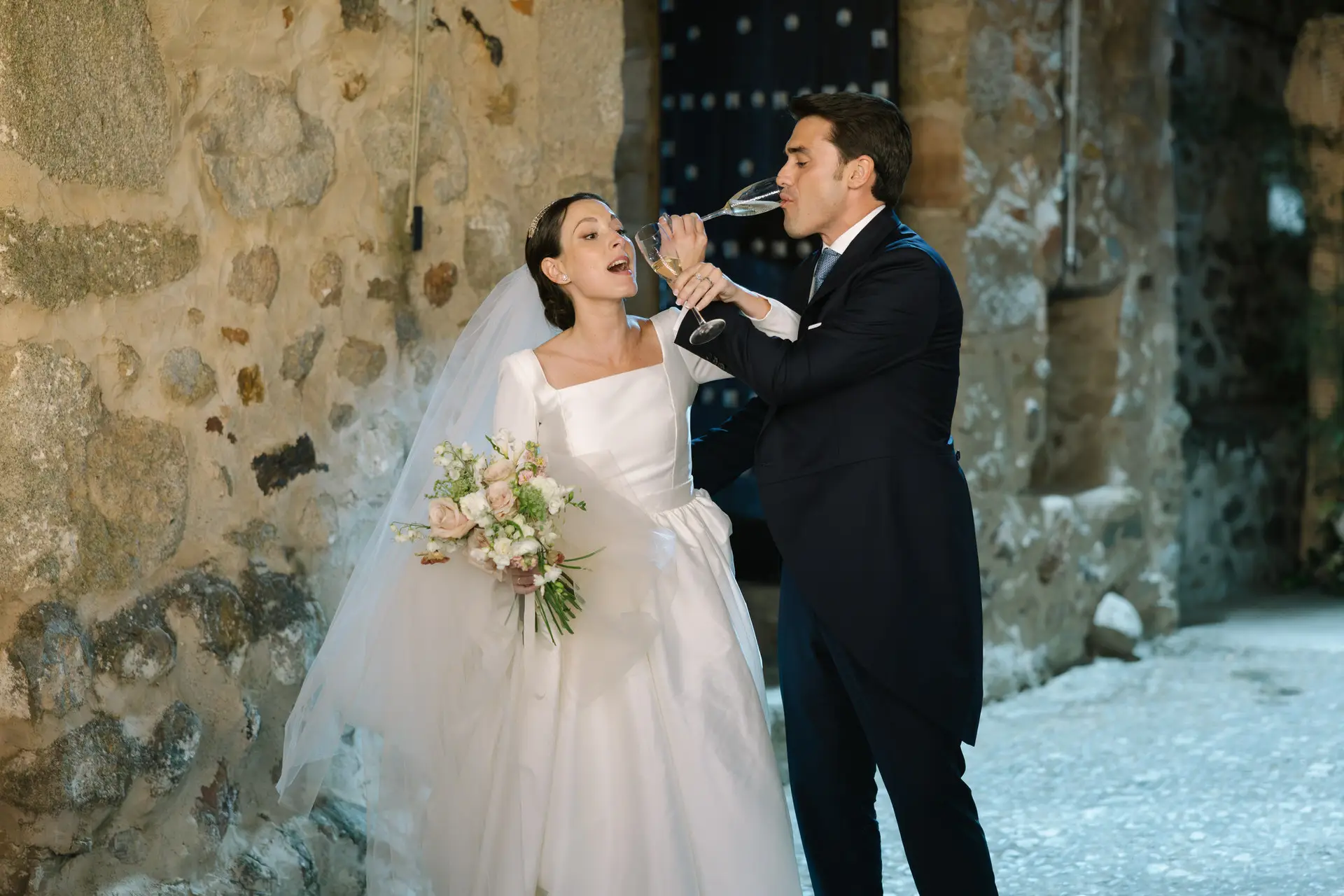 Laura y José Carlos brindan junto a un muro de piedra del castillo, en Jerez de los Caballeros