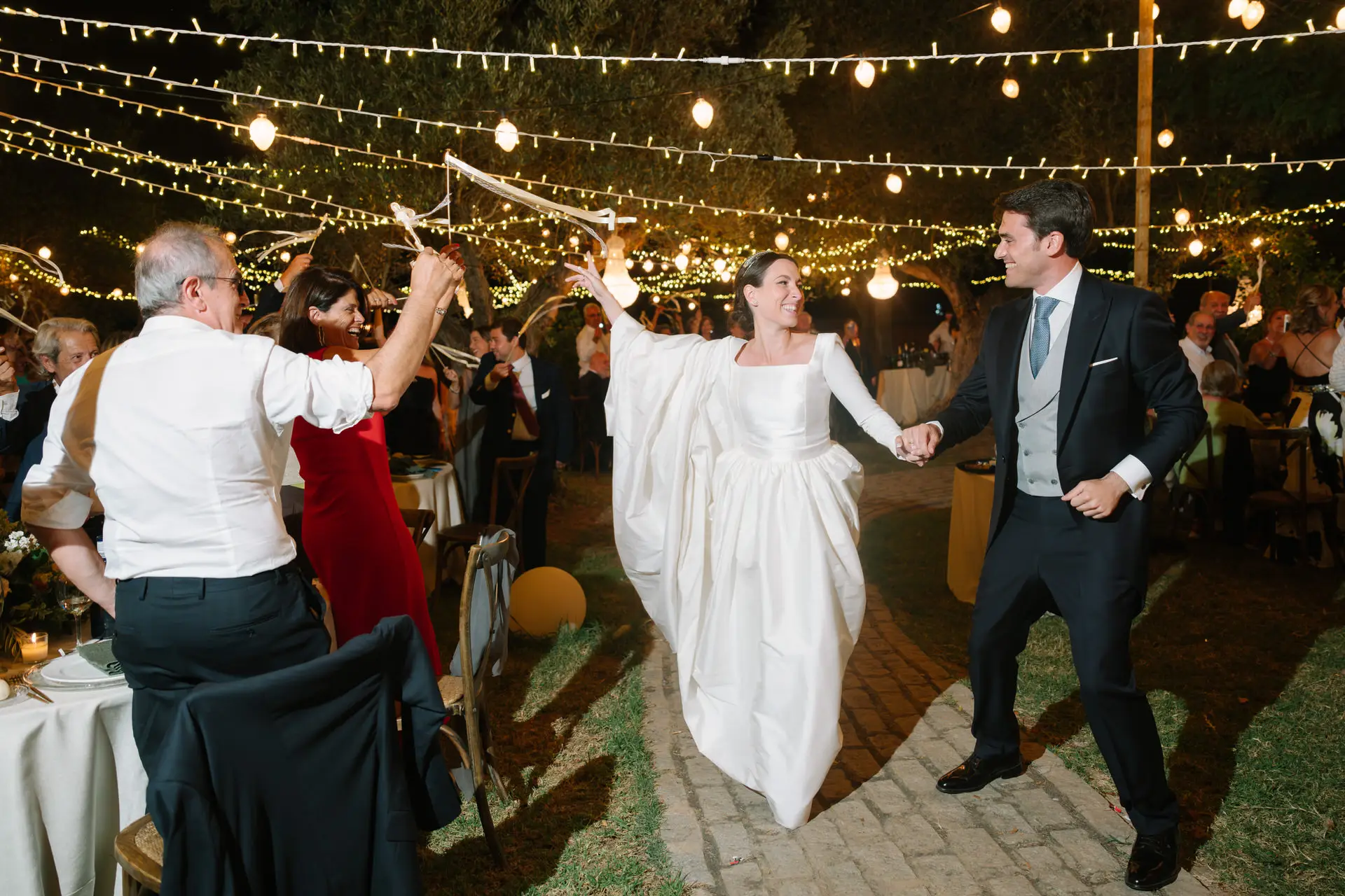 Laura y José Carlos entran al banquete bajo guirnaldas de luces, en Jerez de los Caballeros