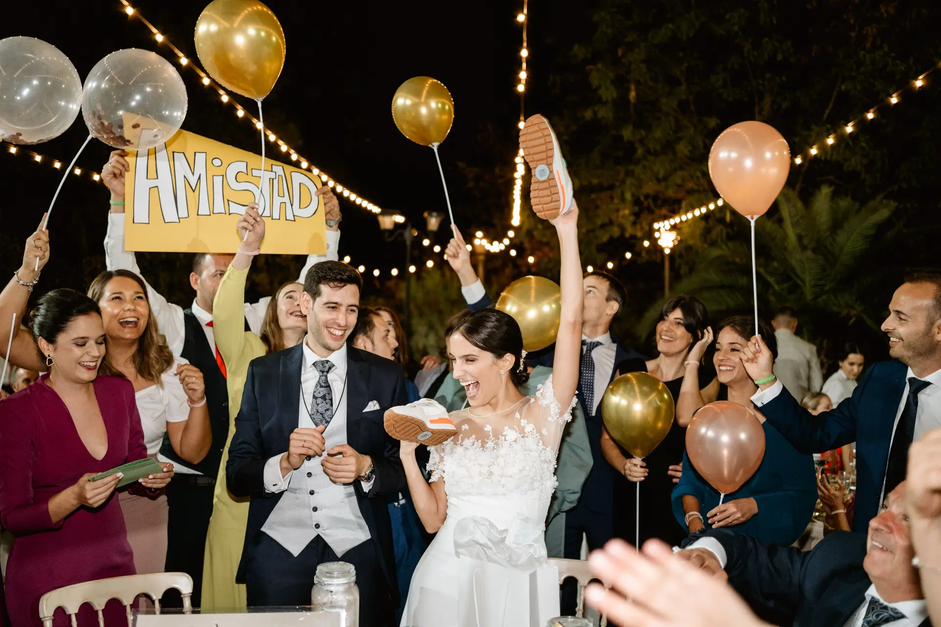 Los invitados levantan globos y un cartel de «Amistad» junto a los novios, en Jerez de los Caballeros
