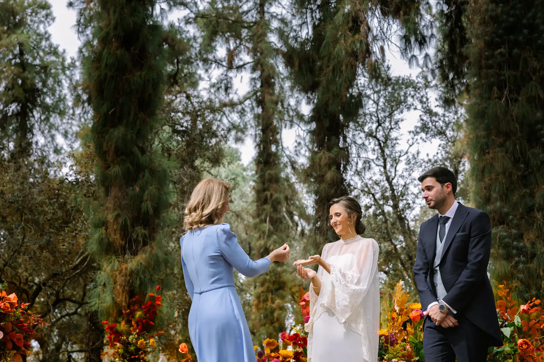 Una invitada se acerca a los novios en una ceremonia en el bosque