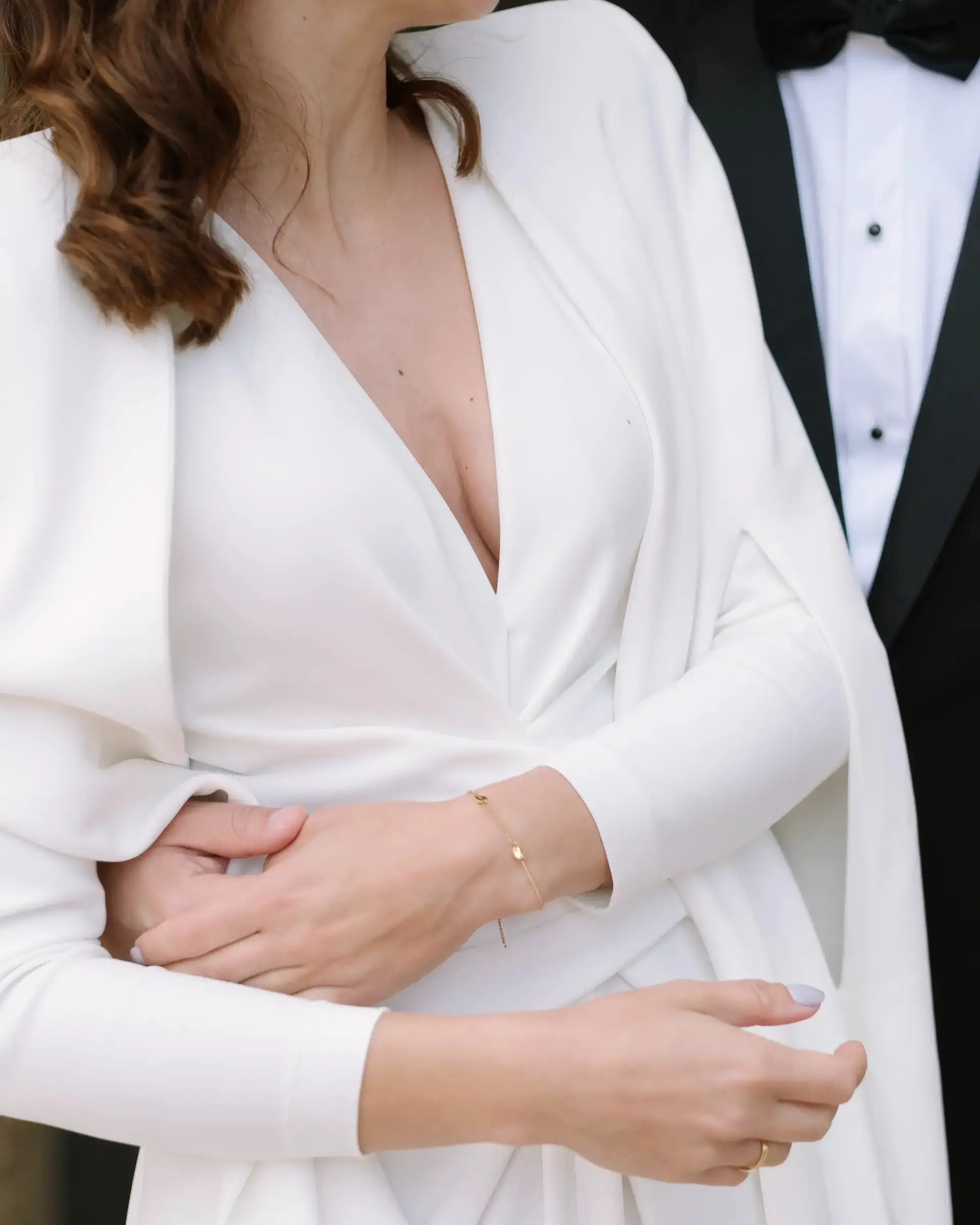 Detalle de las manos de la novia sobre su chaqueta blanca