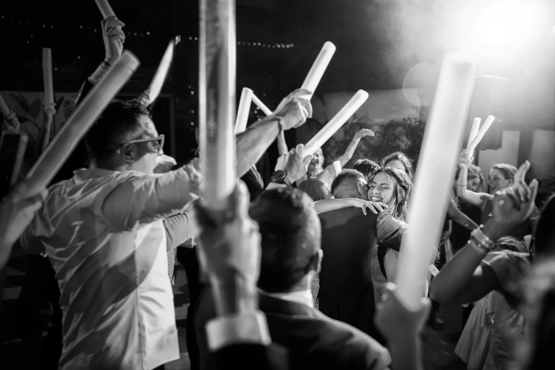 Invitados celebran con barras de luz en la fiesta, en blanco y negro