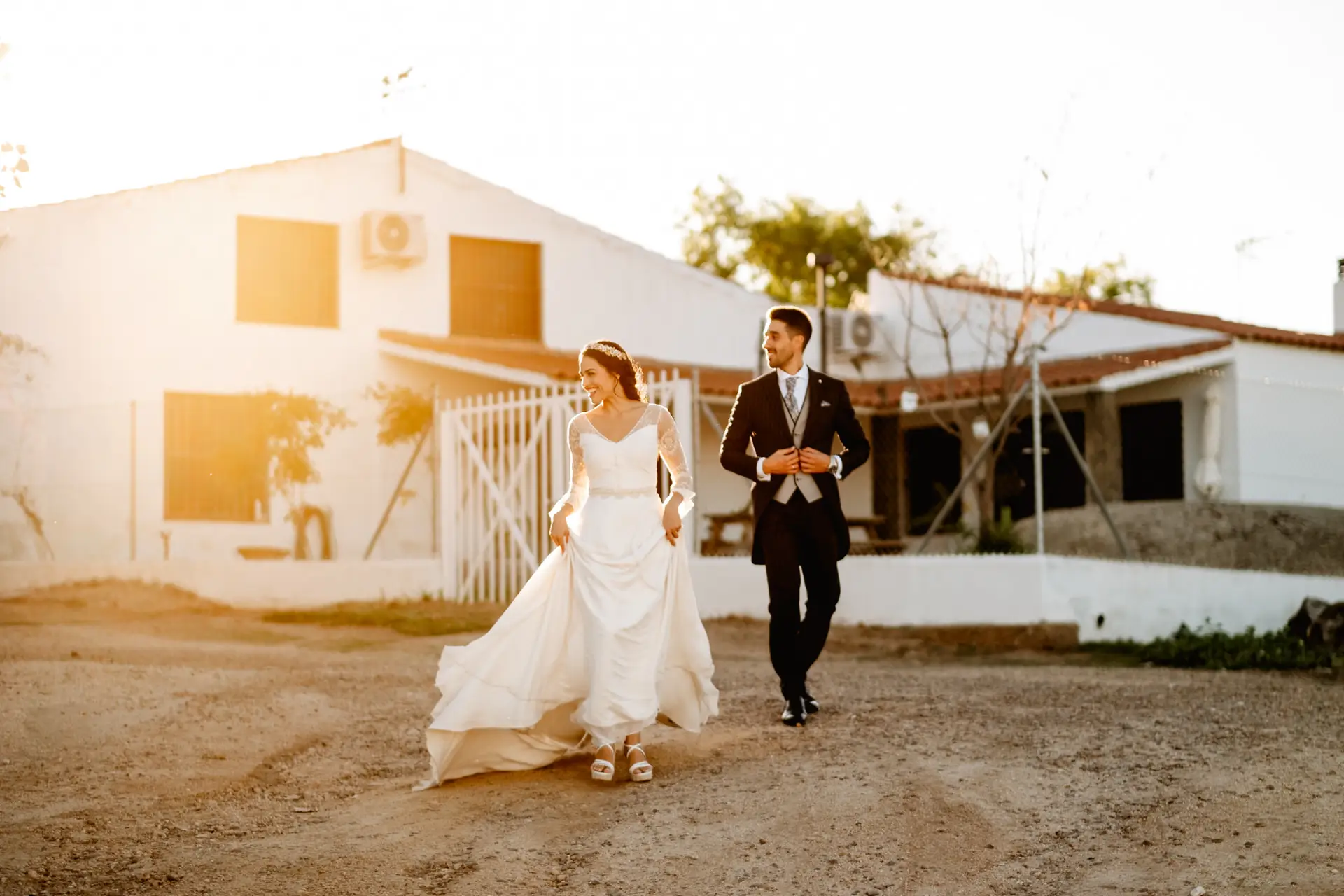 Los novios caminan por el patio del cortijo de Finca La Albuera al atardecer