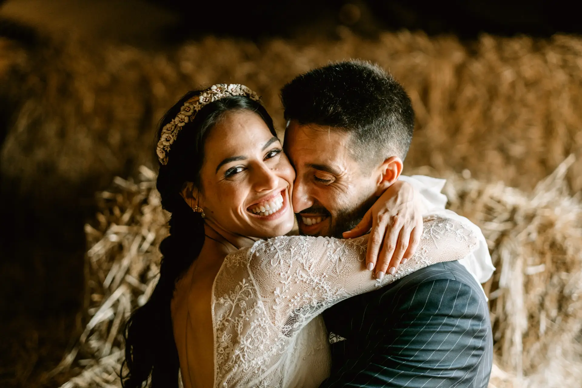 Los novios se abrazan riendo en el pajar de la finca, en Mérida
