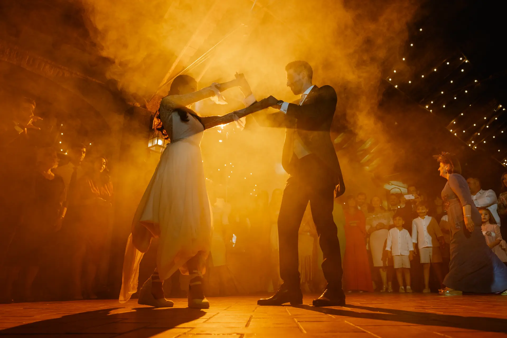 Los novios bailan entre humo naranja en la pista, en Mérida