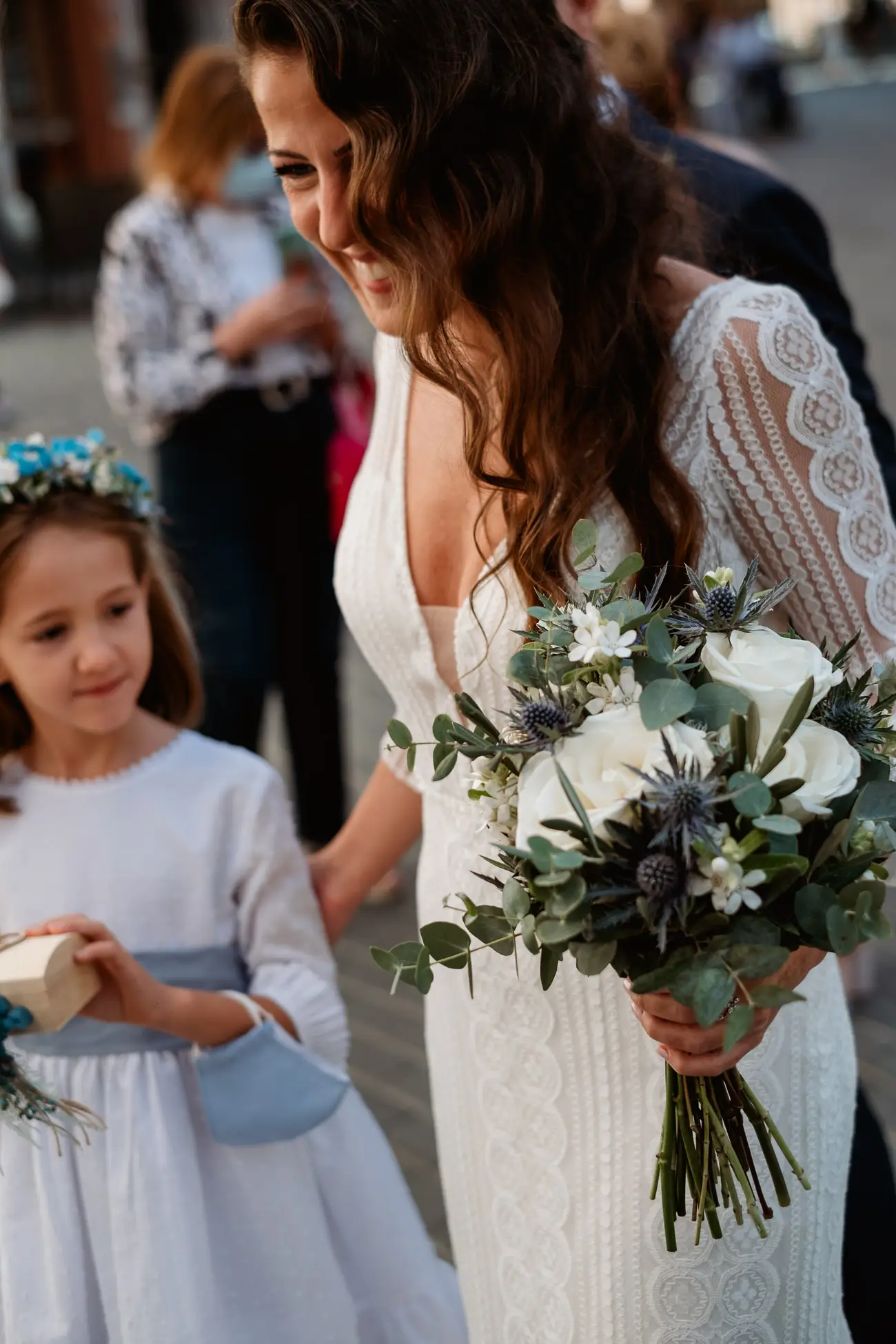La novia sonríe a una niña antes de entrar en la iglesia