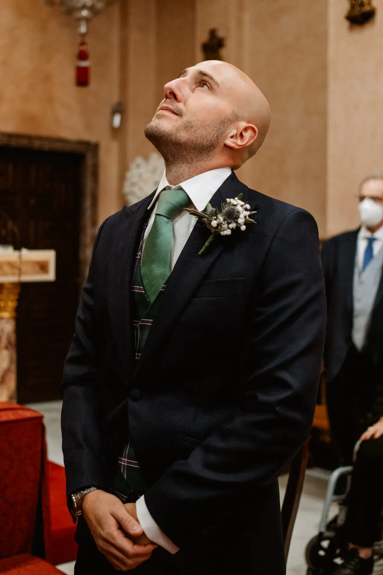 El novio mira hacia arriba en el altar mientras espera