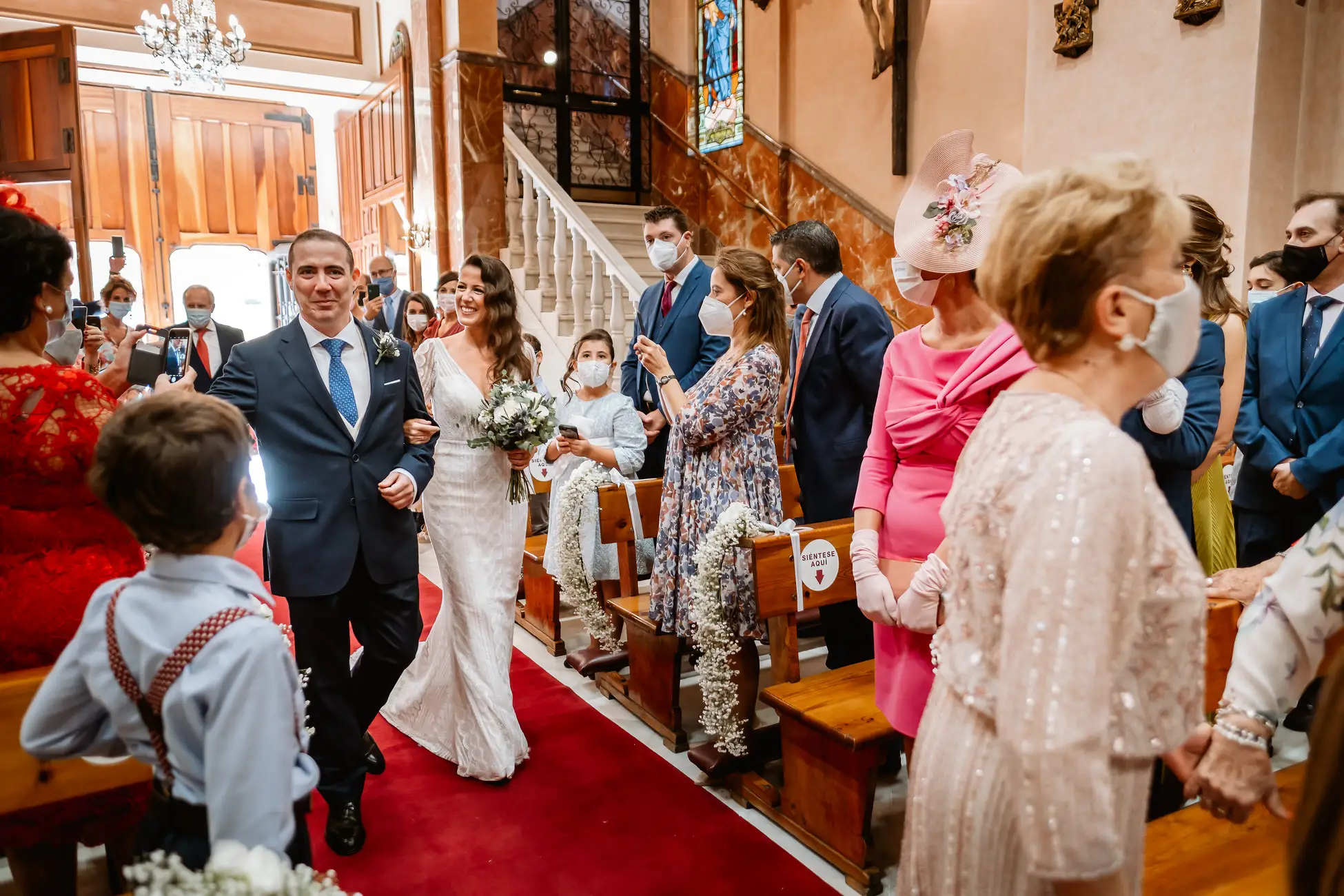 La novia entra en la iglesia del brazo de su acompañante